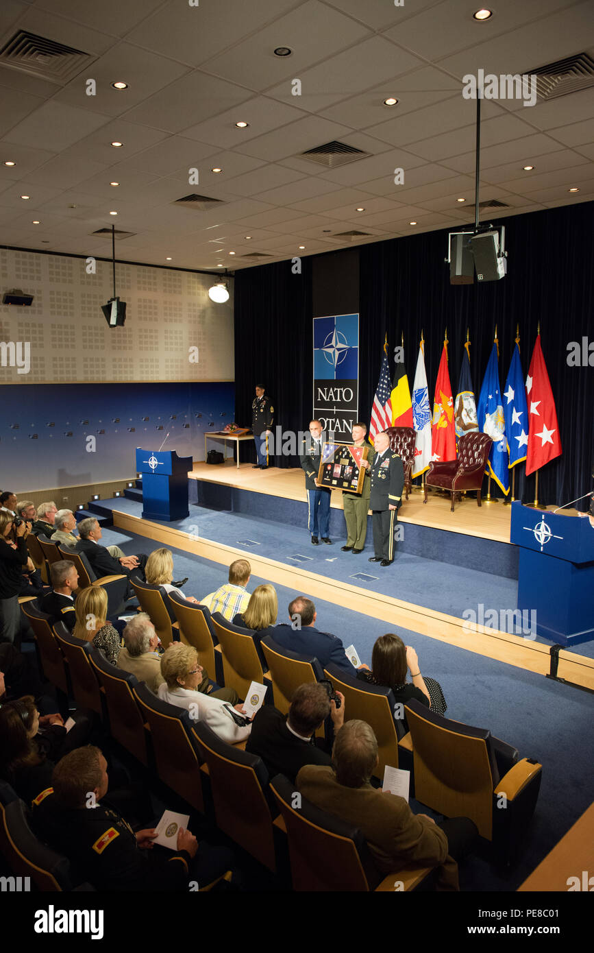 U.S. Army Col. James Becker and U.S. Marines Corps Col. Philippe D. Rogers, both with U.S. Delegation NATO, present a shadow box retracing his career to U.S. Army Lt. Gen. David R. Hogg during his retirement ceremony at NATO Headquarters' auditorium, in Brussels, Belgium, Sept. 15, 2015. (U.S. Army photo by Visual Information Specialist Pierre Courtejoie/Released) Stock Photo