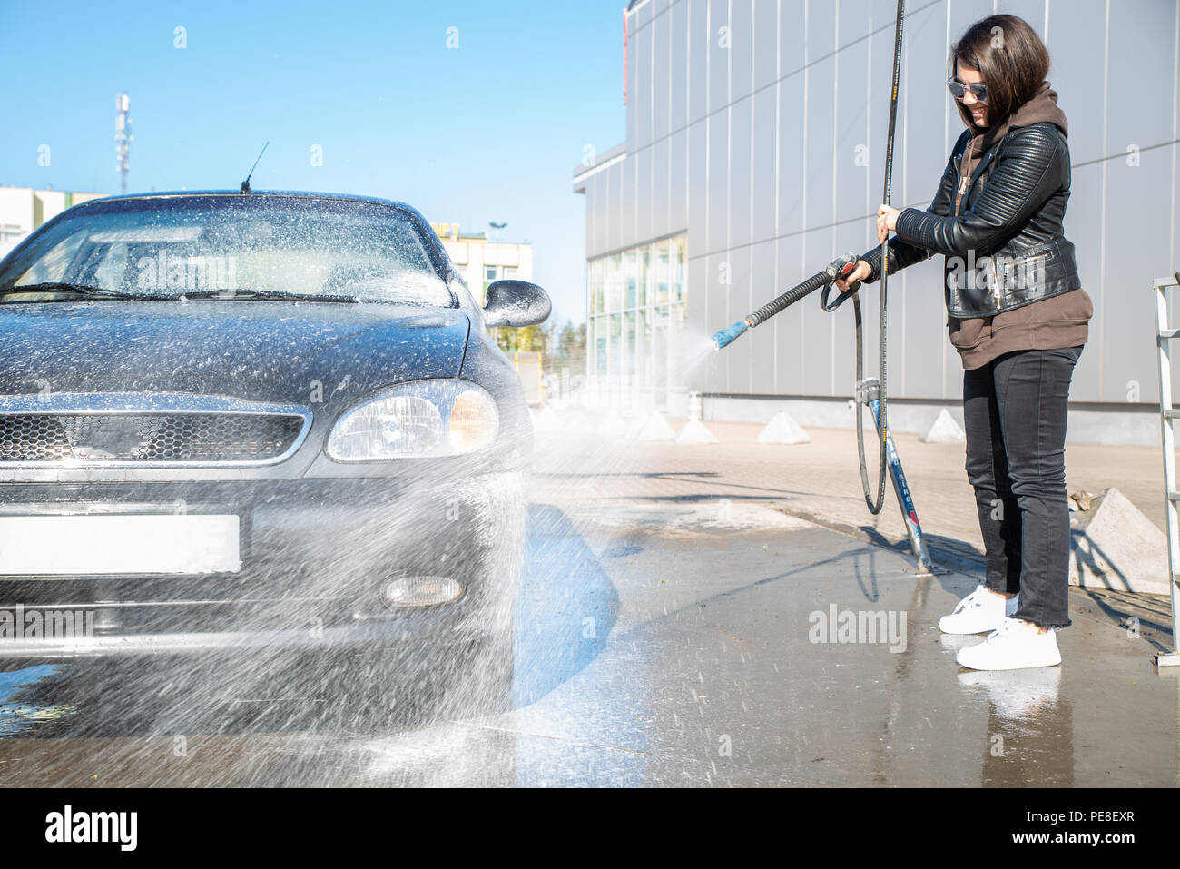 young woman washing car at selfservice carwash Stock Photo Alamy