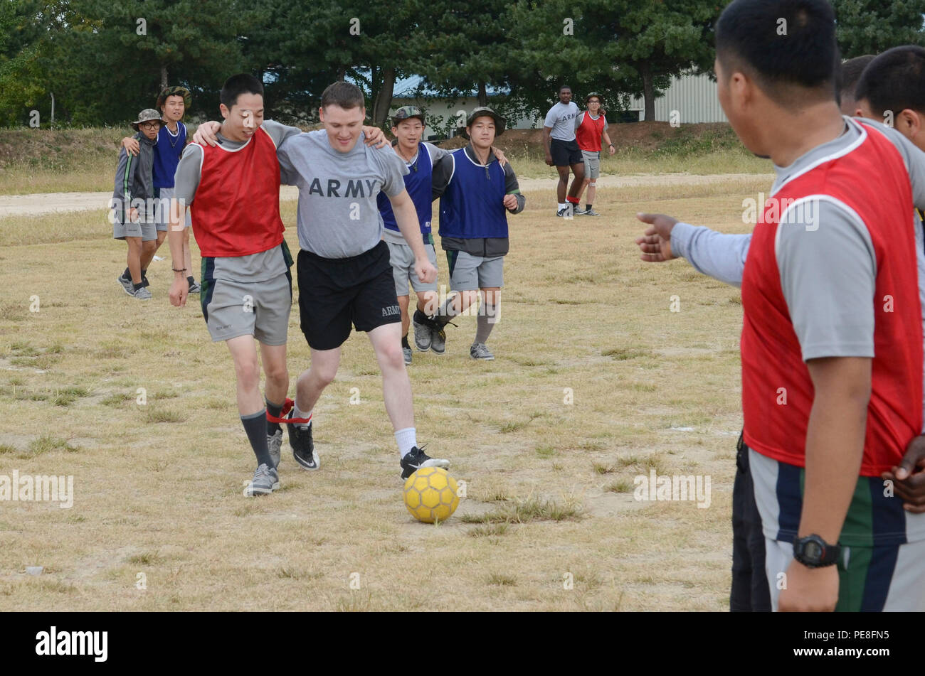 Spc. Benjamin Schoonover, a combat engineer from Bethany, Ill., assigned to Bravo Company, 8th Brigade Engineer Battalion, 2nd Armored Brigade Combat Team, 1st Cavalry Division, participates in a game of 3-legged soccer while tied to a soldier from the Republic of Korea Army’s 1-58th Engineer Battalion, Bucheon, South Korea, Sept. 30, 2015. (U.S. Army photo by Staff Sgt. John Healy, 2ABCT PAO, 1st Cavalry Division) Stock Photo