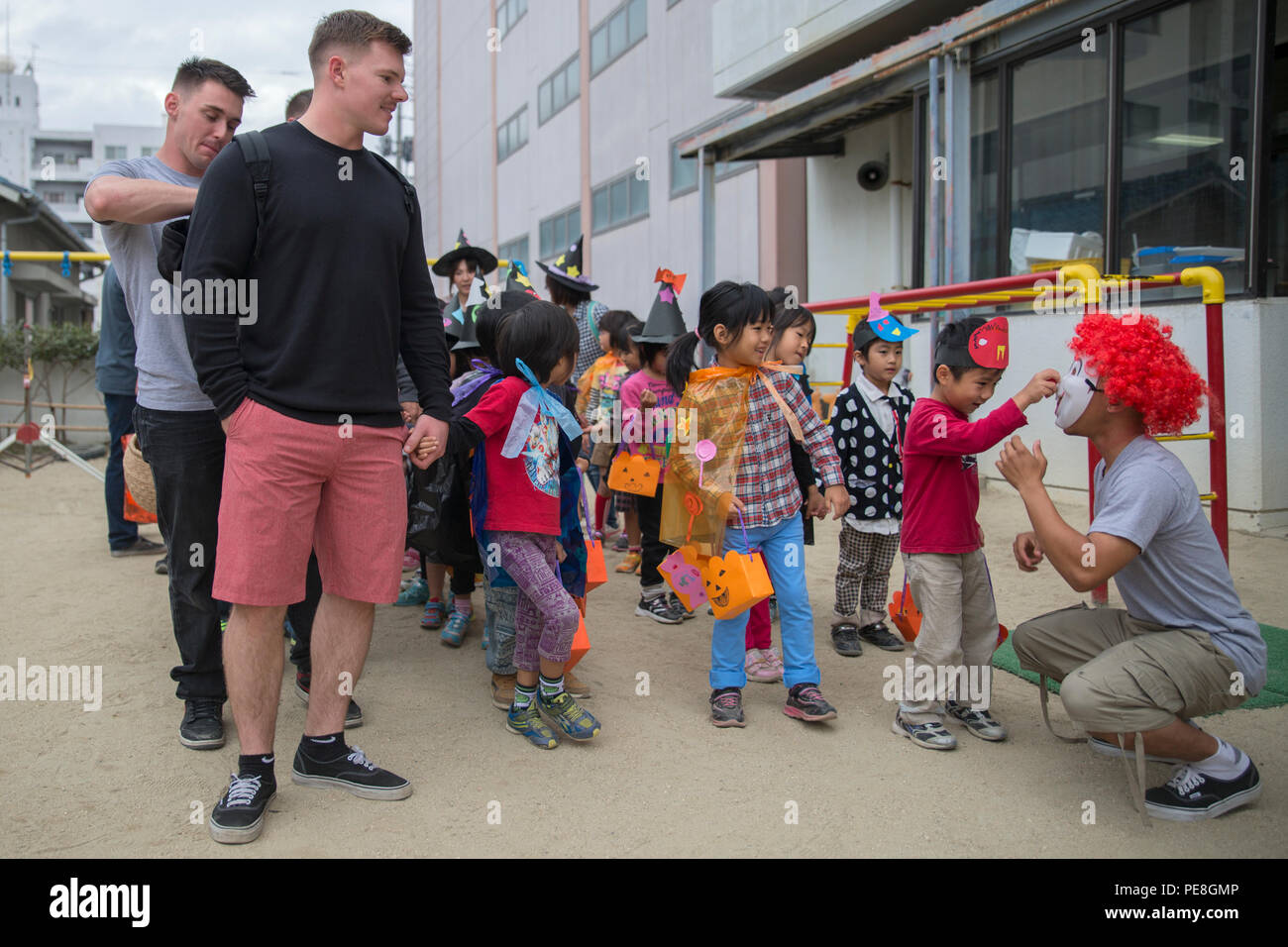 Service members stationed at Marine Corps Air Station Iwakuni, Japan, paired up with Japanese children from the Ekimae Hoikuen Pre-school before walking around town in Iwakuni City, Oct. 27, 2015. The community relations event, hosted by the Marine Memorial Chapel on the air station, gave service members the opportunity to interact with the Japanese youth and teach them about Halloween. Service members are afforded an opportunity to explore Iwakuni and experience the Japanese culture by volunteering for these events. (U.S. Marine Corps photo by Pfc. Aaron Henson/Released) Stock Photo