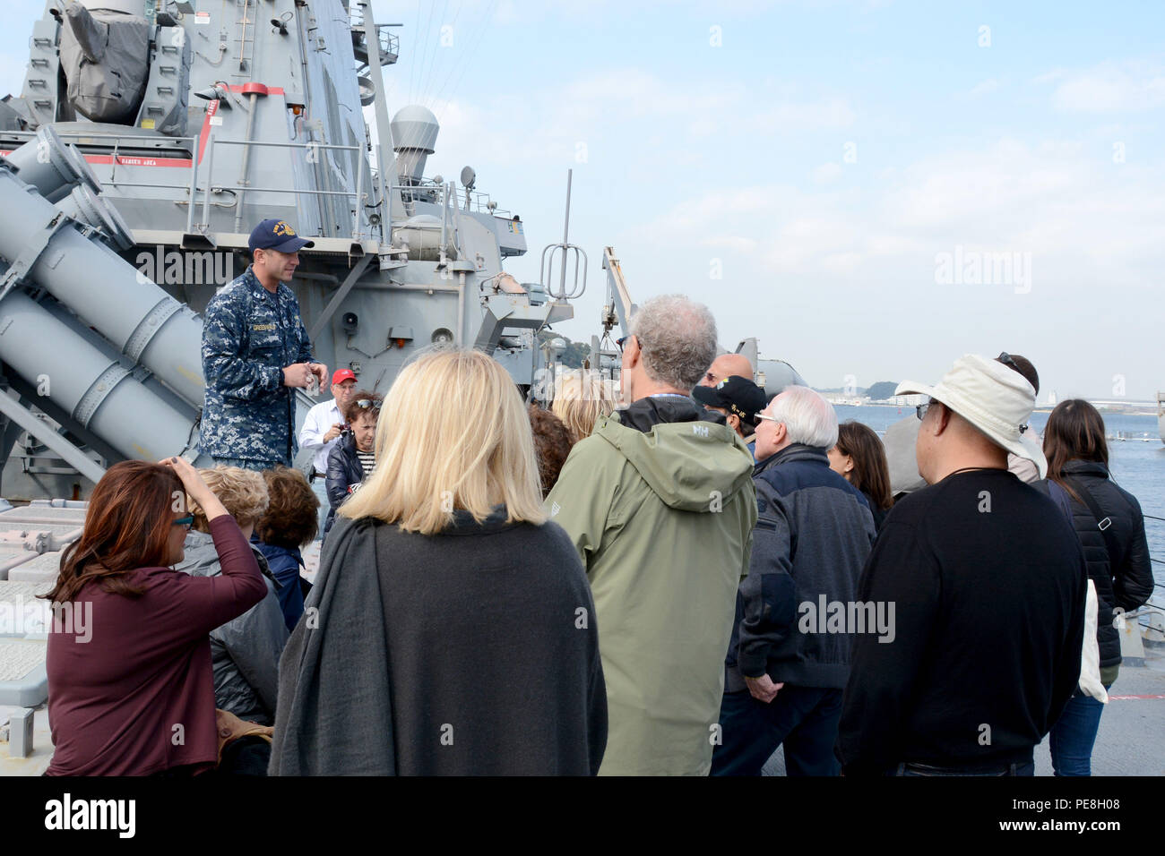 151029-N-XN177-084 YOKOSUKA, Japan (October 29, 2015) – Lt. Jonathan Greenwald, Weapons Officer of the Arleigh Burke-class guided-missile destroyer USS Benfold (DDG 65)  speaks to members of the American Israel Public Affairs Committee about ship operations during a ship tour.  Benfold is moored pier-side at Fleet Activities (FLEACT) Yokosuka. FLEACT provides, maintains, and operates base facilities and services in support of 7th Fleet’s forward-deployed naval forces, 83 tenant commands, and 24,000 military and civilian personnel. (U.S. Navy photo by Mass Communication Specialist 2nd Class Pet Stock Photo