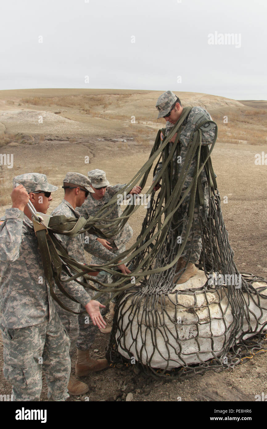 Staff Sgt. Jonathon Velarde, right, works with fellow Soldiers from the 1st Battalion, 200th Infantry, to secure the sling load cargo net surrounding a baby Pentaceratops skull. From left to right, Sgt. Daniel Hinojo, Sgt. Bryan Haworth and Staff Sgt. Jason Ruetschilling use their skills to assist Velarde. The New Mexico Army National Guard conducted a civil-military community support project Oct. 28-29, assisting the New Mexico Museum of Natural History and Science. Aviation, infantry and transportation Soldiers worked to prepare, airlift and transport 65-million-year-old Pentaceratops dinosa Stock Photo