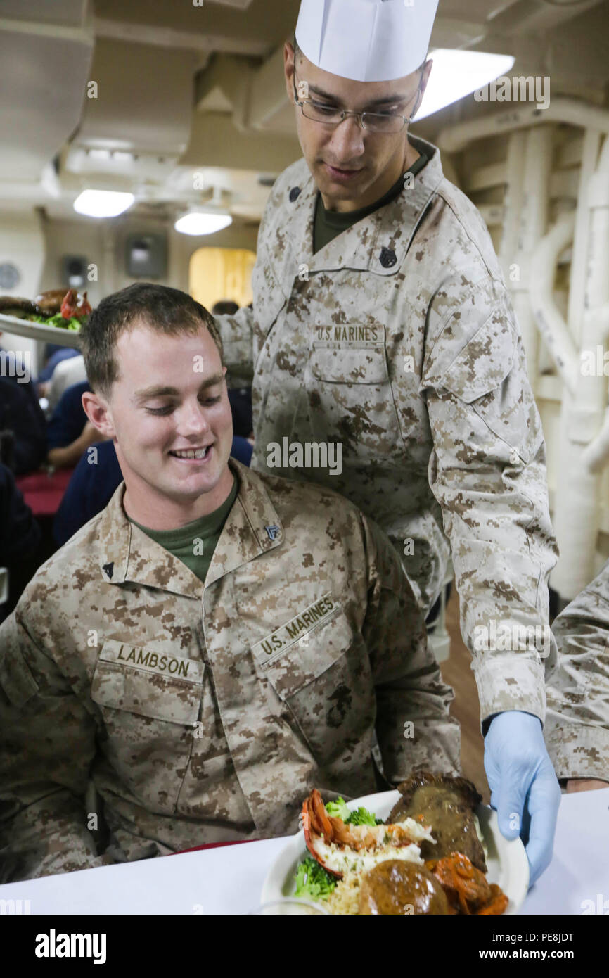 Gulf Of Aden (Oct. 29, 2015) U.s. Marine Staff Sgt. James Leach, Right,  Serves Cpl. Cody Lambson His Meal For The October Birthday Dinner Aboard  The Uss Anchorage (Lpd 23). Leach Is