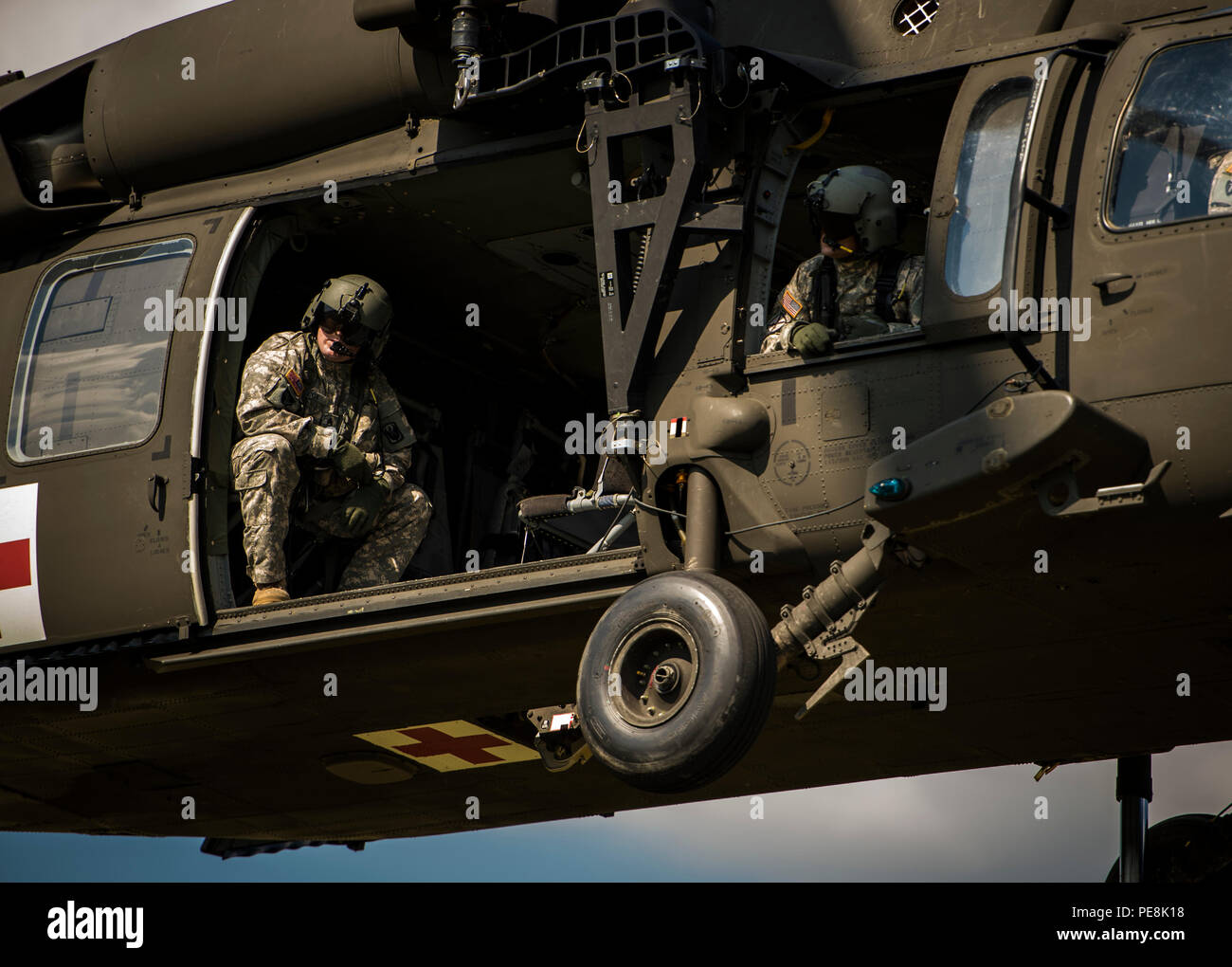 Soldiers with the Mississippi Army National Guard Medical Evacuation Team look out the window while on board a UH-60 Black Hawk helicopter at Camp Shelby Joint Forces Training Center, Miss., during Exercise Turbo Distribution, Oct. 29, 2015. The U.S. Transportation Command exercise tests the Joint Task Force Port-Opening's ability to deliver and distribute cargo during humanitarian relief operations. (U.S. Air Force photo by Staff Sgt. Marianique Santos/Released) Stock Photo