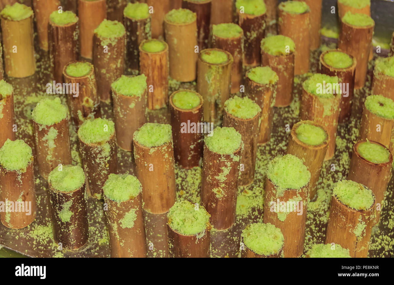Putu bambu, traditional malaysian and indonesian sweet cooked with rice flour, pandan leafs, palm sugar, coconut and steamed in bamboo pipes at the  C Stock Photo