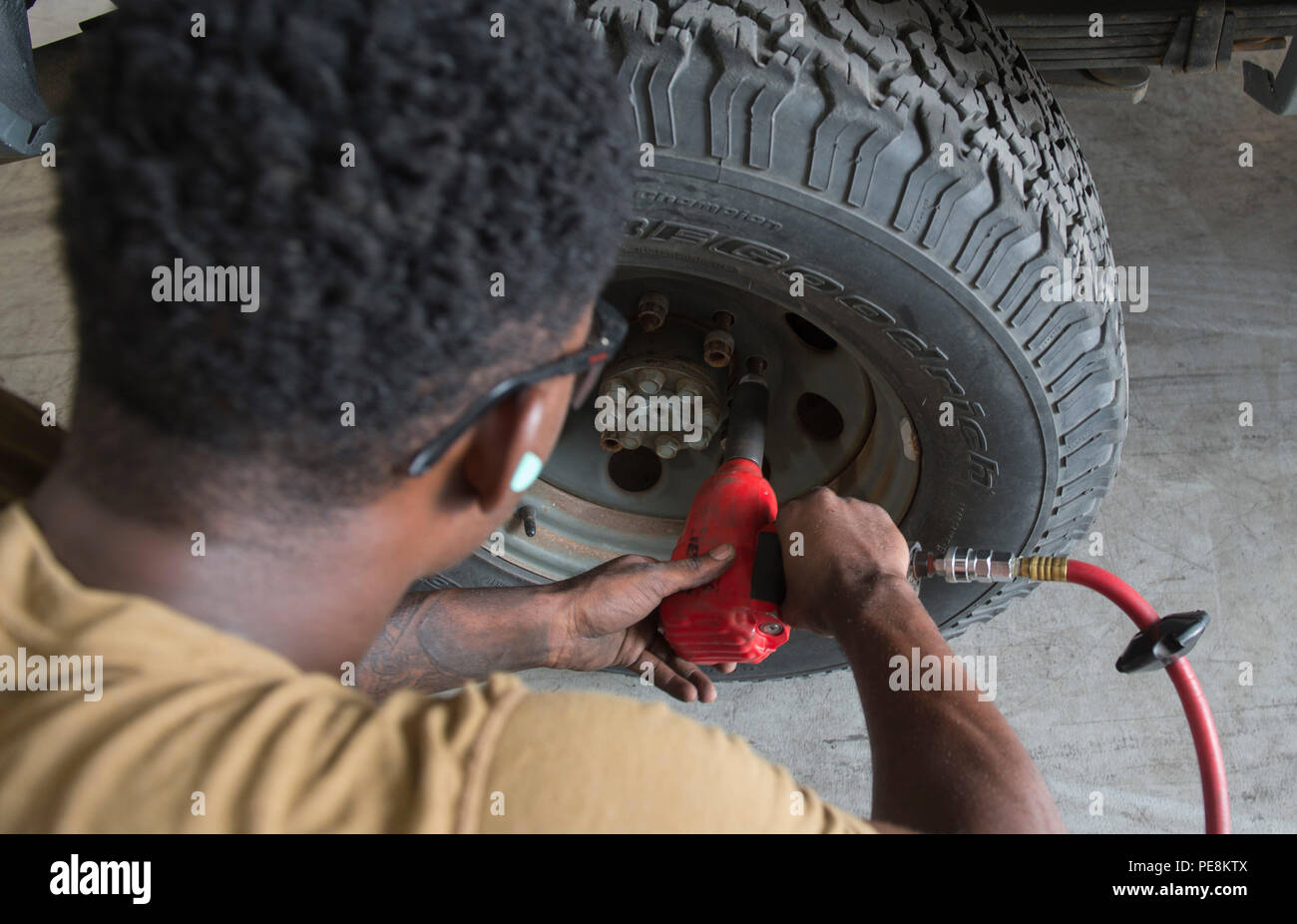 U.S. 5TH FLEET AREA OF OPERATIONS (Oct. 28, 2015) Constructionman Charles Tims, assigned to Commander, Task Group (CTG) 56.1, removes the lugnuts on a tire to check the brake pads on a truck during routine maintenance procedures in U.S. 5th Fleet area of operations Oct. 28, 2015. CTG 56.1 conducts mine countermeasures, explosive ordnance disposal, salvage-diving, and force protection operations throughout the U.S. 5th Fleet area of operations. (U.S. Navy photo by Mass Communication Specialist 2nd Class Shannon Burns/Released) Stock Photo