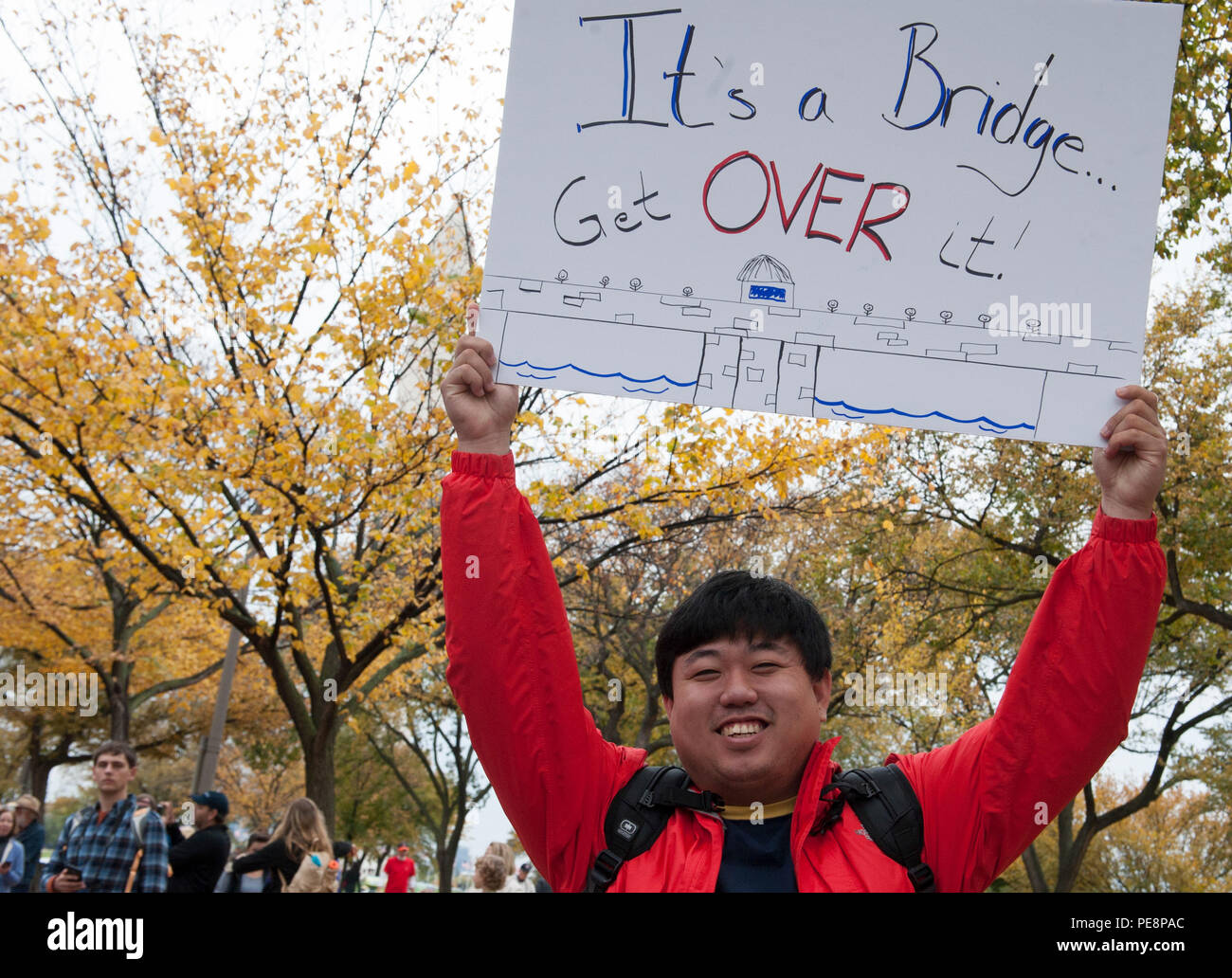 Michael Yee holds a sign to encourage participants in the 40th Annual Marine Corps Marathon (MCM) in Washington, Oct. 25, 2015. The sign references the MCM course segment 'Beat the Bridge' wherein participants must reach the 14th Street Bridge at a fourteen-minute per mile pace. (U.S. Marine Corps photo by Cpl. Diana Sims/Released) Stock Photo
