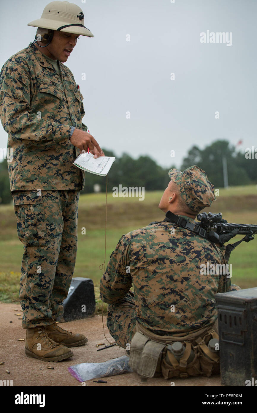 Cpl. Mathew J. Rice, a marksmanship coach with Marksmanship Training  Company, Weapons and Field Training Battalion, advises a recruit of Alpha  Company, 1st Recruit Training Battalion, how to improve his shooting  accuracy
