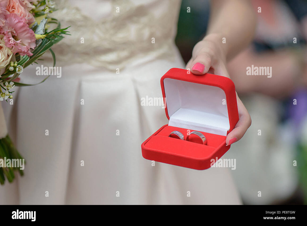 Cropped shot of Caucasian woman, holding a jewelry red box with matching silver or platinum wedding rings, in preparation for a wedding Stock Photo