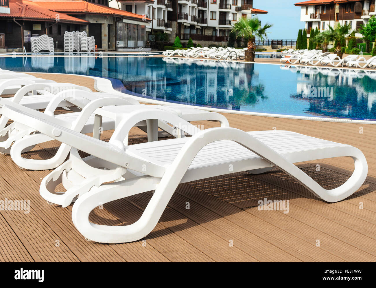 White plastic chaise lounges by the pool. Closeup Stock Photo Alamy