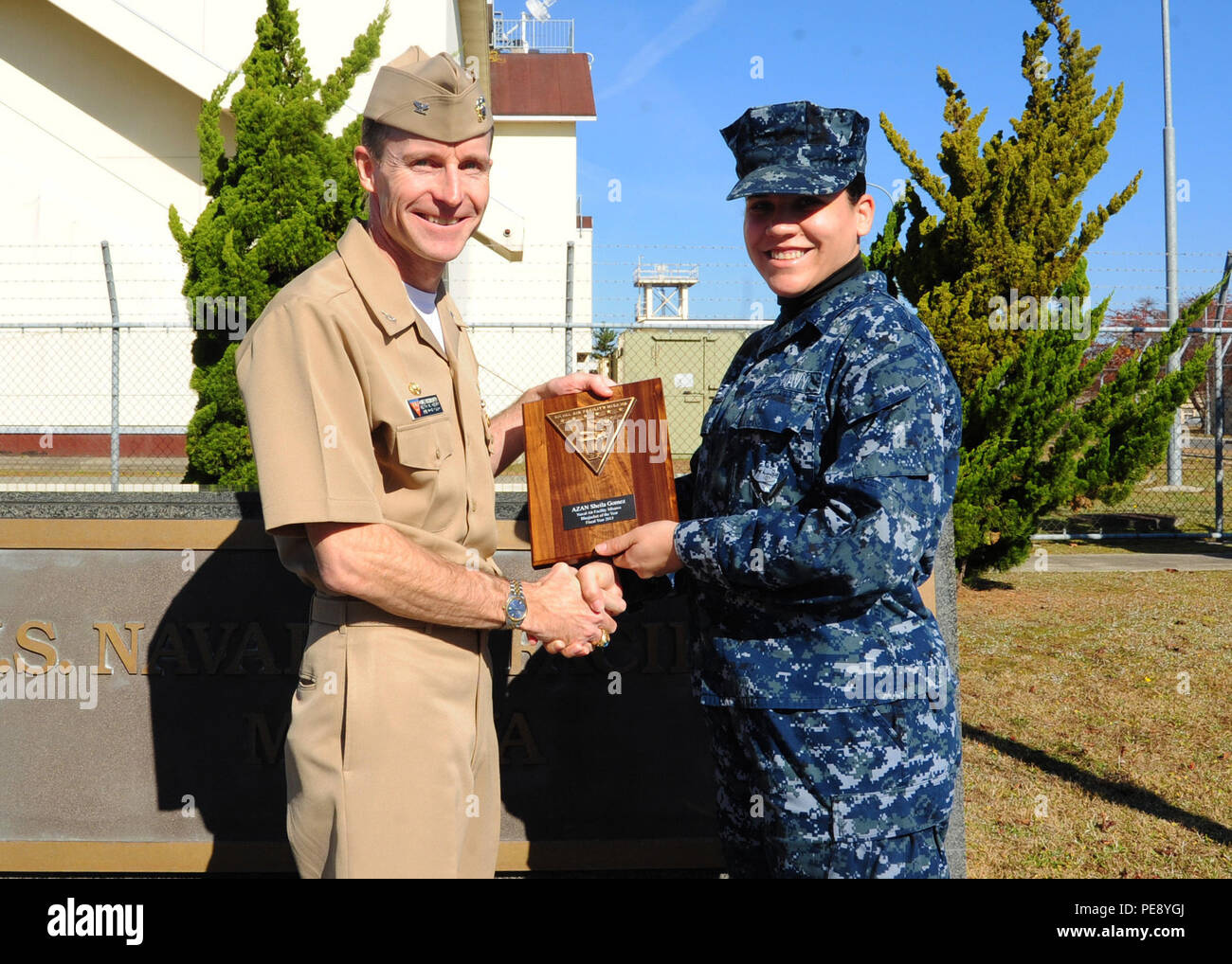 151105-N-EC644-006 MISAWA, Japan (Nov. 5, 2015) Capt. Keith Henry, commanding officer of Naval Air Facility (NAF) Misawa, presents the Blue Jacket of the Year (BJOY) plaque to Aviation Maintenance Administrationman Airman Sheila Marie Burgos from Coamo, Puerto Rico. Burgos was selected as NAF Misawa's BJOY for Fiscal Year 2015. (U.S. Navy photo by Senior Chief Mass Communication Specialist Ryan C. Delcore/Released) Stock Photo