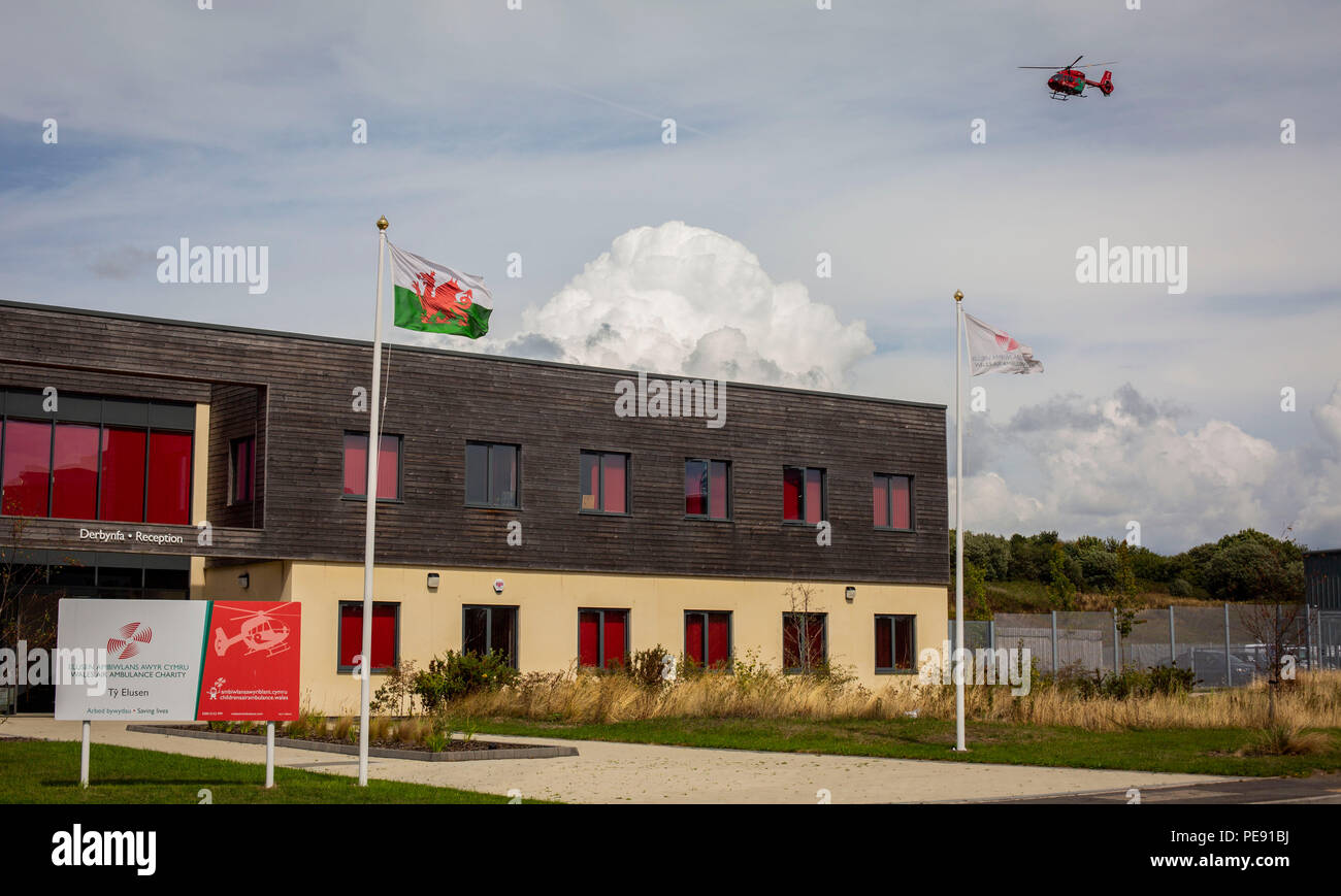 A Wales Air Ambulance helicopter flies above the Wales Air Ambulance charity headquarters in Dafen, near Llanelli. Stock Photo