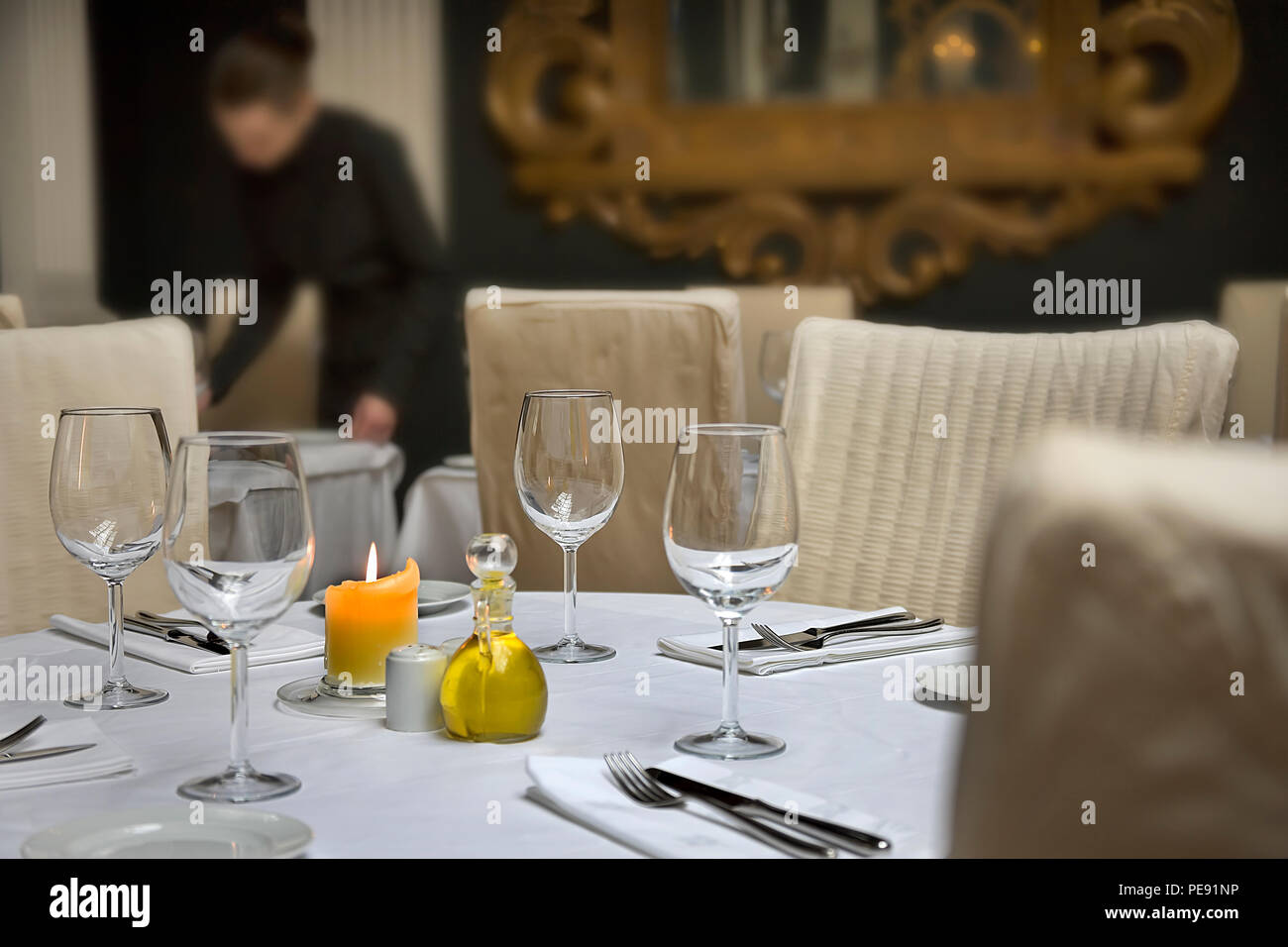 Restaurant Table Setting With Staff Member In Soft Focus Background And Table Level Pov Stock Photo Alamy