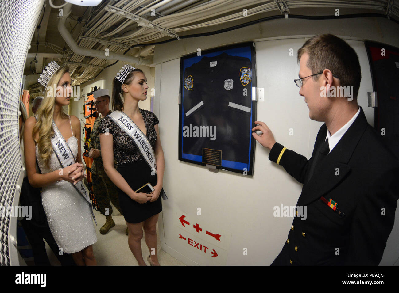 151109-N-WD757-145 NEW YORK (Nov. 9, 2015) Miss New Jersey USA Jessielyn Palumbo, left, and Miss Wisconsin USA Kate Redeker, middle, look at a uniform used by a New York Police Department officer during 9/11 displayed aboard the amphibious transport dock ship USS New York (LPD 21) during a tour at a formal reception for Veterans Week New York City. Sailors from local Navy units are participating in Veterans Week New York City 2015 to honor the service of all our nation’s veterans.  (U.S. Navy photo by Mass Communication Specialist 1st Class Carlos M. Vazquez II/Released) Stock Photo