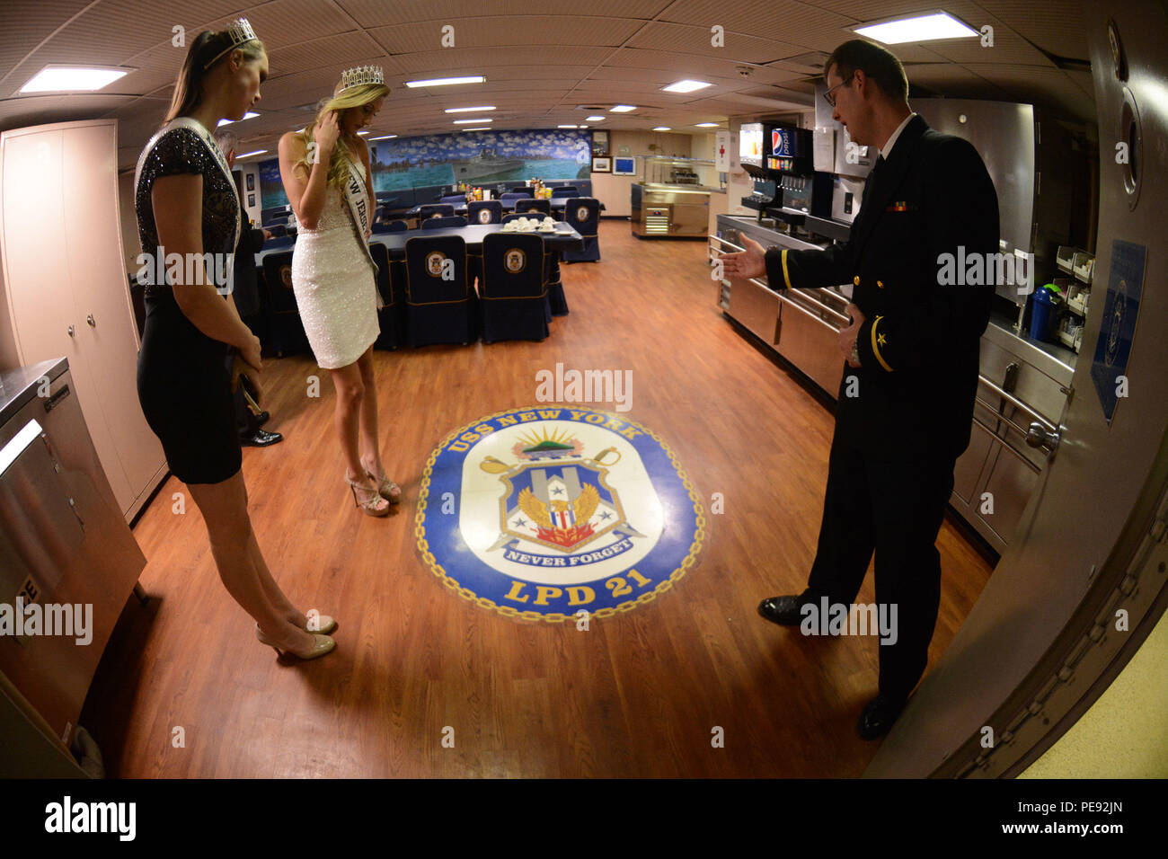 151109-N-WD757-172 NEW YORK (Nov. 9, 2015) Ensign Michael Brown explains the meaning of the ship’s crest to Miss New Jersey USA Jessielyn Palumbo and Miss Wisconsin USA Kate Redeker during a tour aboard the amphibious transport dock ship USS New York (LPD 21) during a formal reception for Veterans Week New York City. Sailors from local Navy units are participating in Veterans Week New York City 2015 to honor the service of all our nation’s veterans. (U.S. Navy photo by Mass Communication Specialist 1st Class Carlos M. Vazquez II/Released) Stock Photo