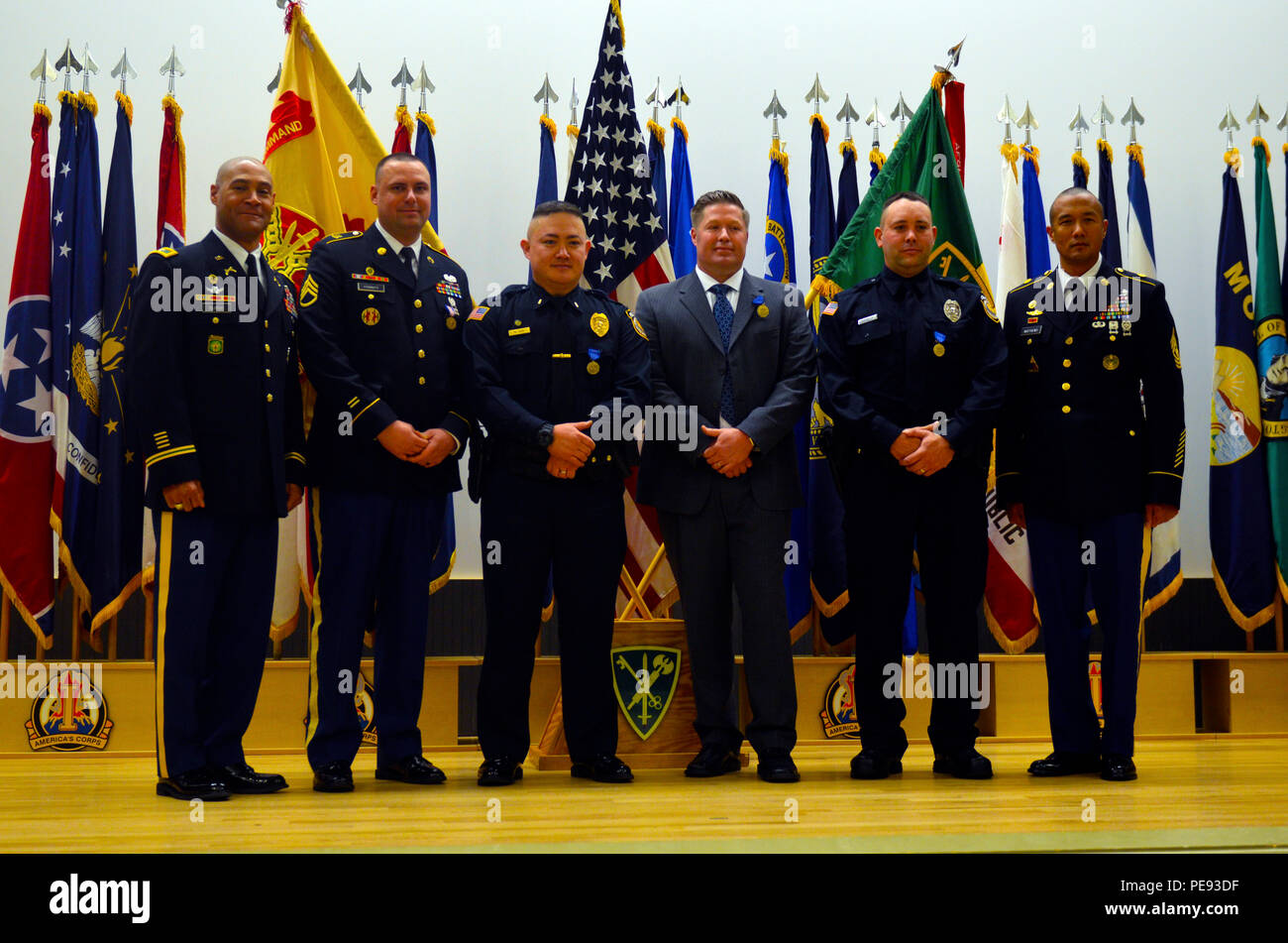 (From left to right) Col. Christopher A. Burns, commander, 42nd Military Police Brigade and director of Emergency Services for JBLM, Staff Sgt. Scott Franz, 504th Military Police Battalion, 42nd MP Brigade, Lt. Marcus Todd, Detective James Earnest, Officer James Smet, Department of the Army civilian police officers, and Command Sgt. Maj. Jon D Matthews, 42nd Military Police Brigade, all pose for a group photo during an awards ceremony at the French Theater on Joint Base Lewis McChord, Wash., Nov. 10, 2015. Franz and the three DA civilian police officers were all awarded for their heroism and v Stock Photo