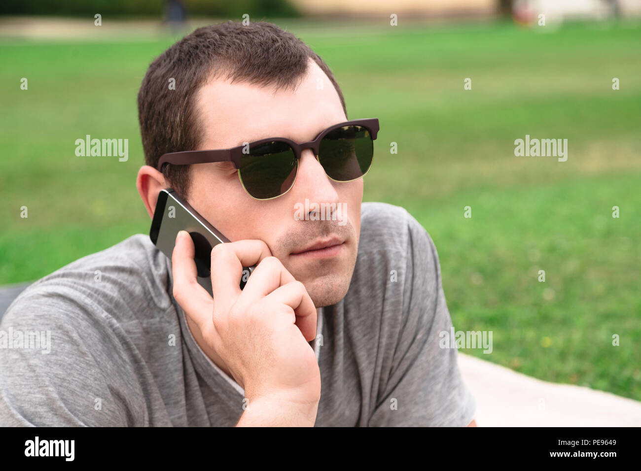 Young handsome man using mobile phone in park Stock Photo