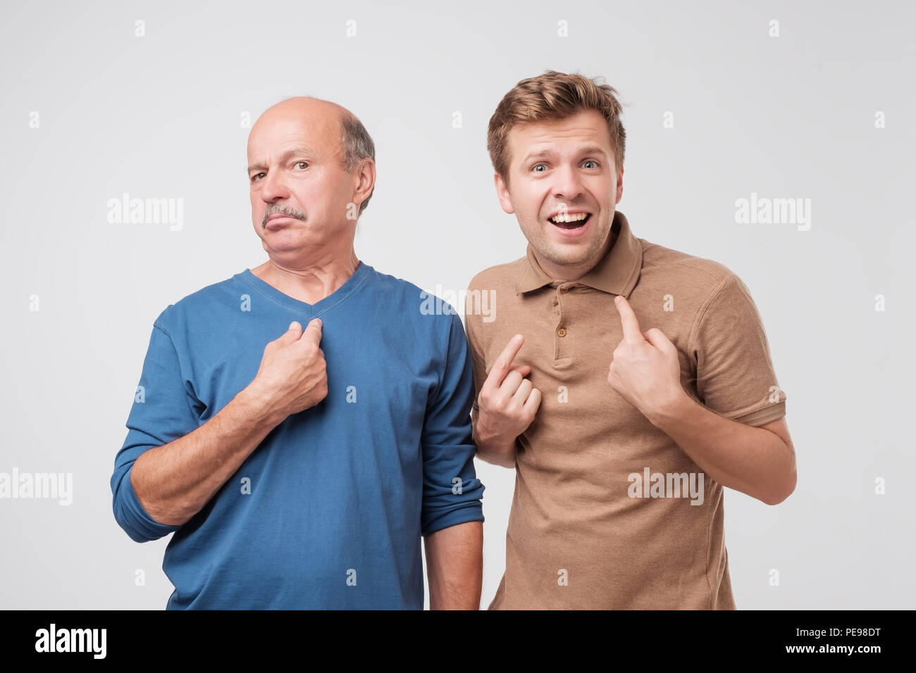Two shocked, surprised, mature men looking asking question, you talking to me, you mean me. Select me please concept. Human emotions, facial expressio Stock Photo