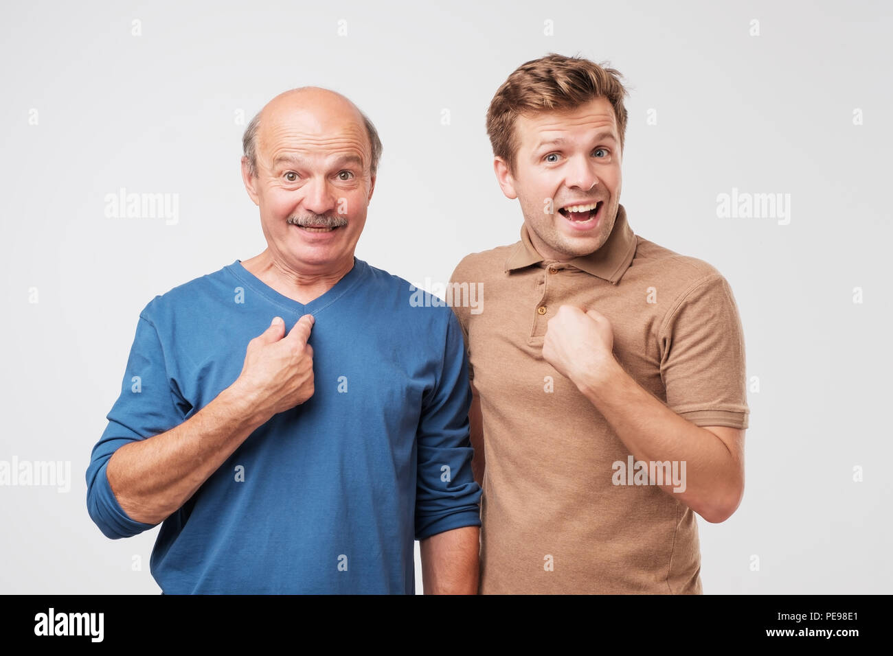 Two shocked, surprised, mature men looking asking question, you talking to me, you mean me. Select me please concept. Human emotions, facial expressio Stock Photo