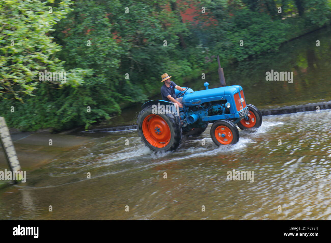 A Fordson Major tractor crosses the River Skell in Ripon with other