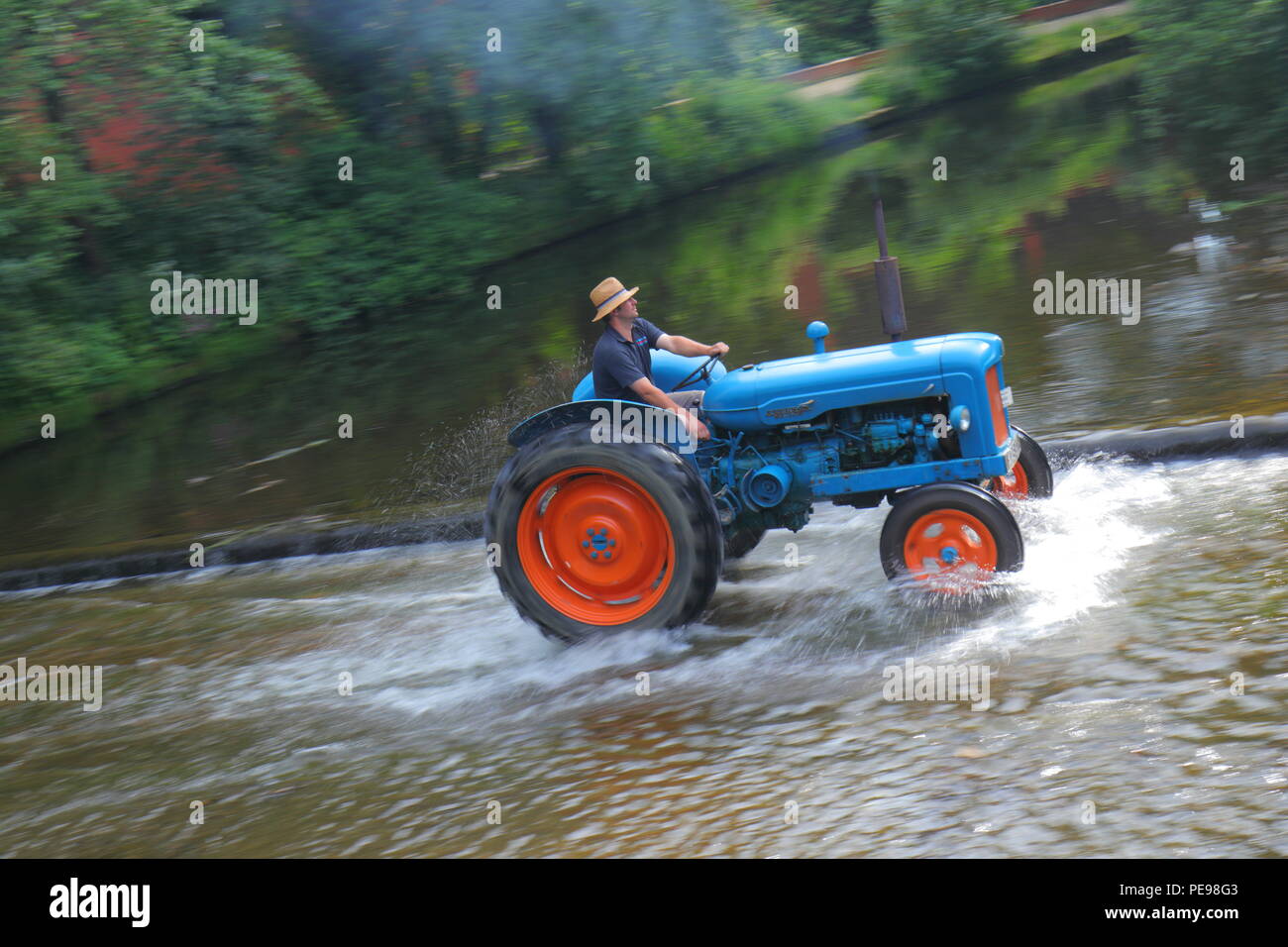 A Fordson Major tractor crosses the River Skell in Ripon with other