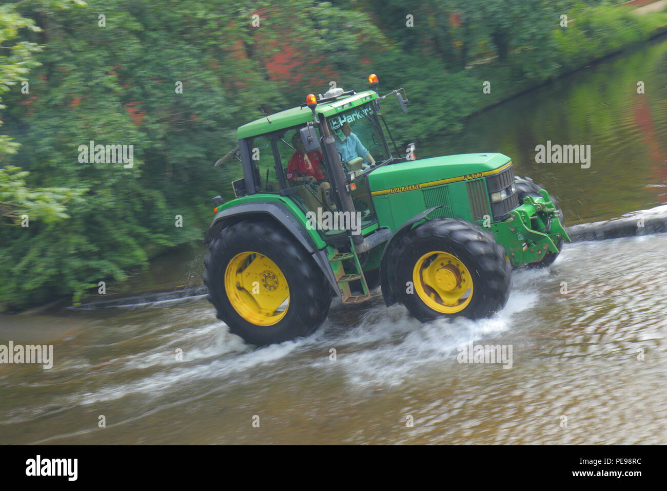 A John Deere 6900 tractor crosses the River Skell in Ripon with a