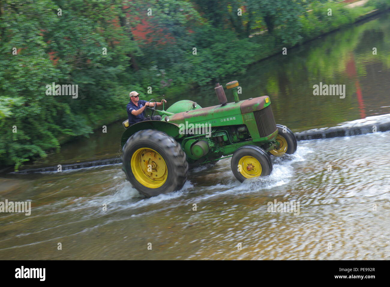 A John Deere Tractor crosses the River Skell in Ripon during a convoy