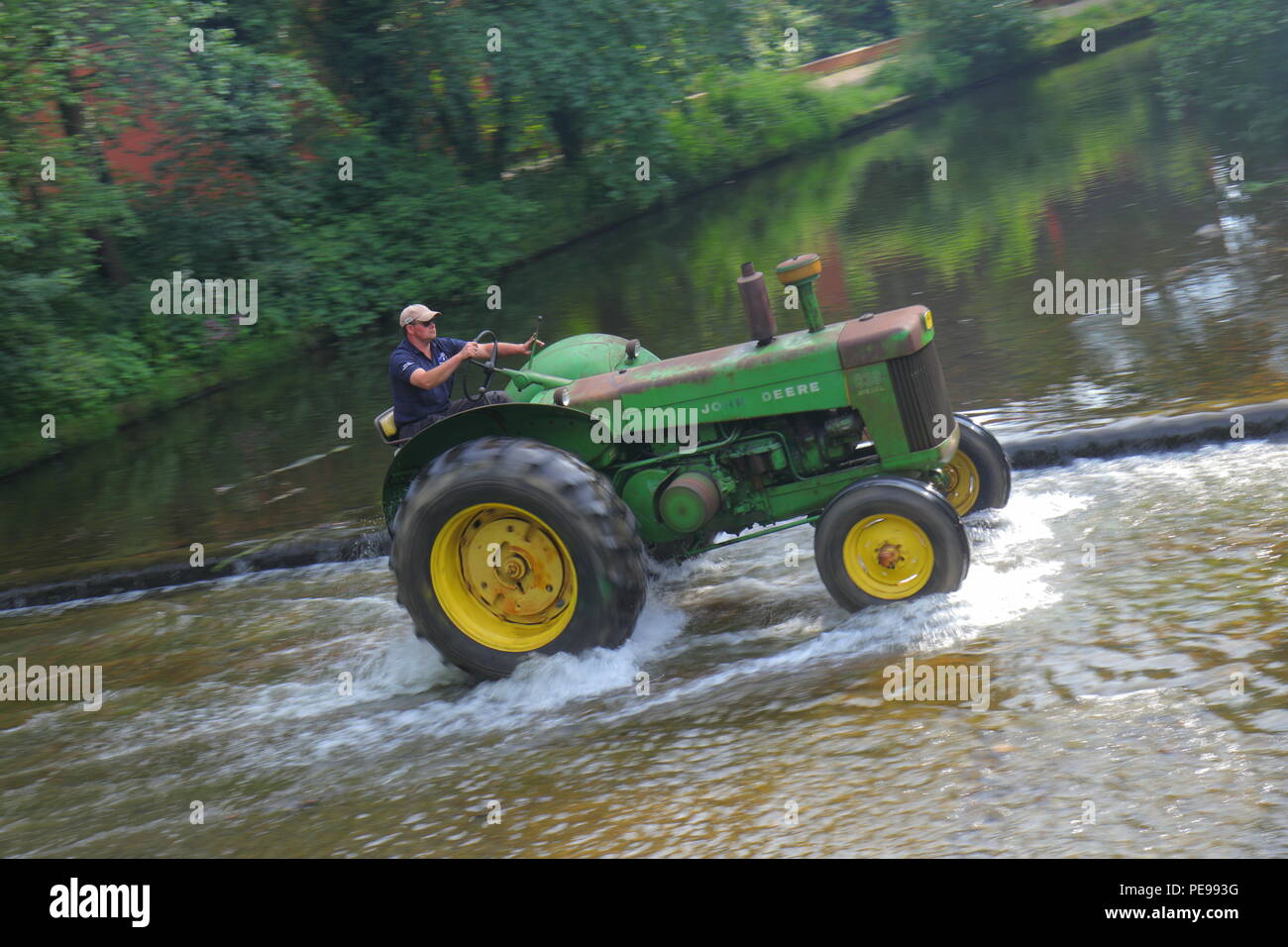 A John Deere Tractor crosses the River Skell in Ripon during a convoy