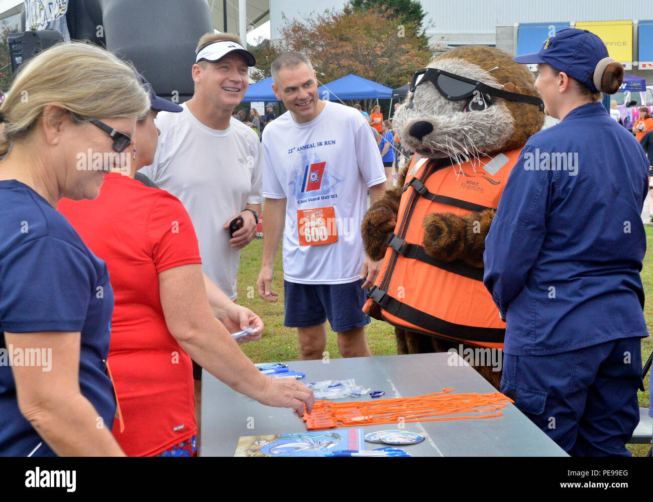 Rear Adm. Steven P. Metruck (left) and Master Chief Petty Officer Mark Pearson (right) talk with shipmates and Sammy the Sea Otter, Saturday, Nov. 7, 2015, during Coast Guard Day festivities in Portsmouth, Va. The city of Portsmouth is a designated Coast Guard City and held a festival to honor the men and women of the service and their families. (Coast Guard photograph by Petty Officer 3rd Class Joshua Canup) Stock Photo