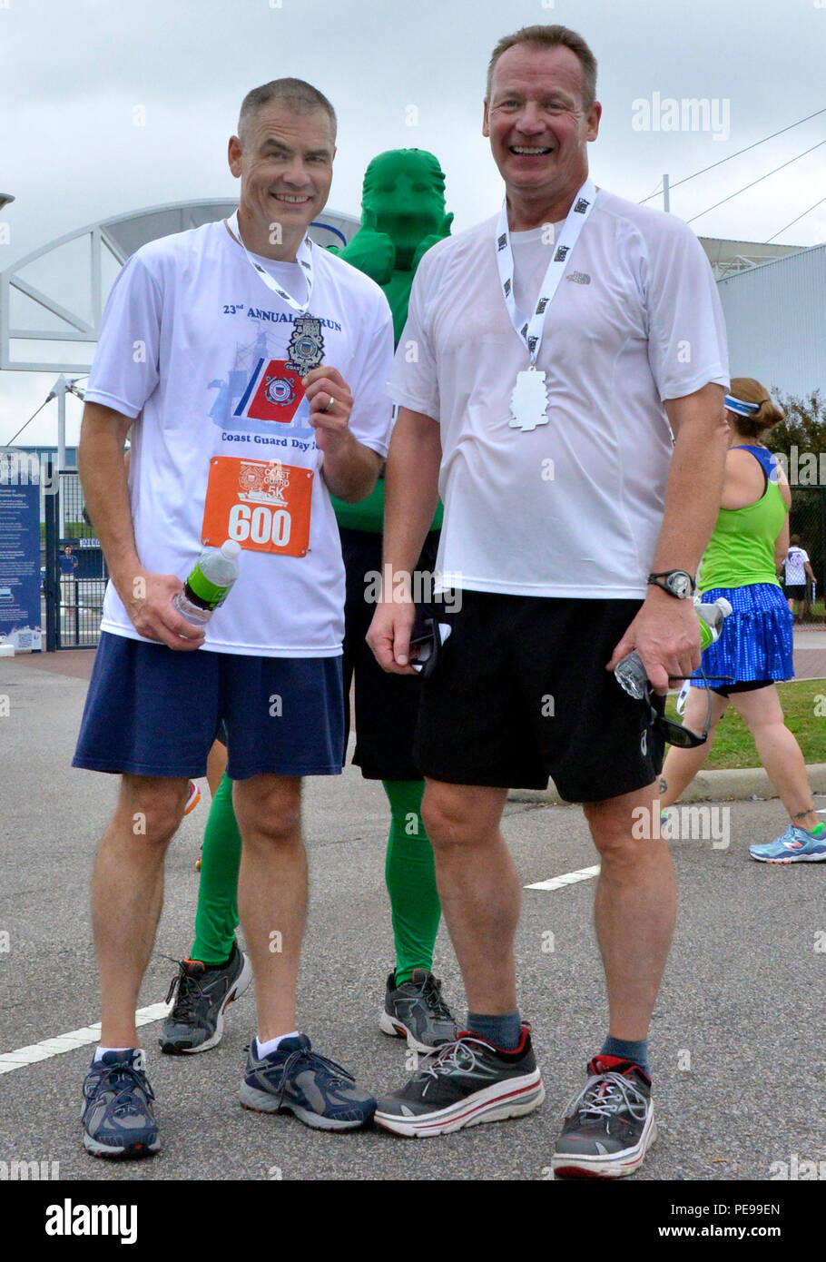 Master Chief Petty Officer Mark Pearson (left) and Rear Adm. Steven P. Metruck (right) pose with Green Man Saturday, Nov. 7, 2015, during Coast Guard Day festivities in Portsmouth, Va. The city of Portsmouth is a designated Coast Guard City and held a festival to honor the men and women of the service and their families. (Coast Guard photograph by Petty Officer 3rd Class Joshua Canup) Stock Photo