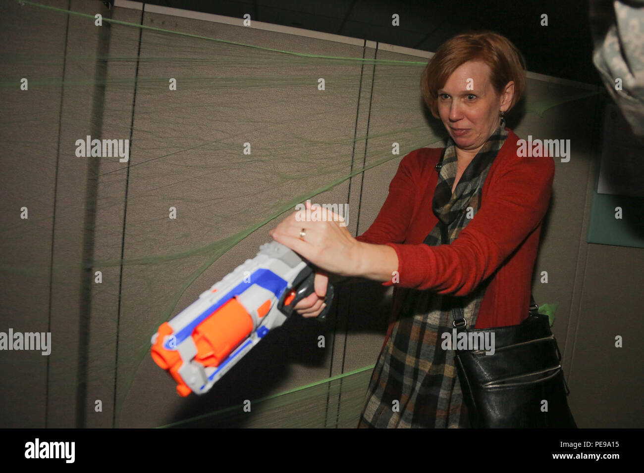 Kelly Paul, spouse of Sgt. 1st Class Christophe Paul, assigned to the 55th Signal Company (COMCAM), uses a Nerf gun to shoot at Zombies during the Company annual Halloween party, Fort George G. Meade, Oct. 29, 2015. The gathering was organized by the Family Readiness Group and is designed to bring Soldiers and their family together to celebrate Halloween and also to build esprit de corp. (U.S. Army photo by Sgt. 1st Class Christophe D. Paul/Released) Stock Photo