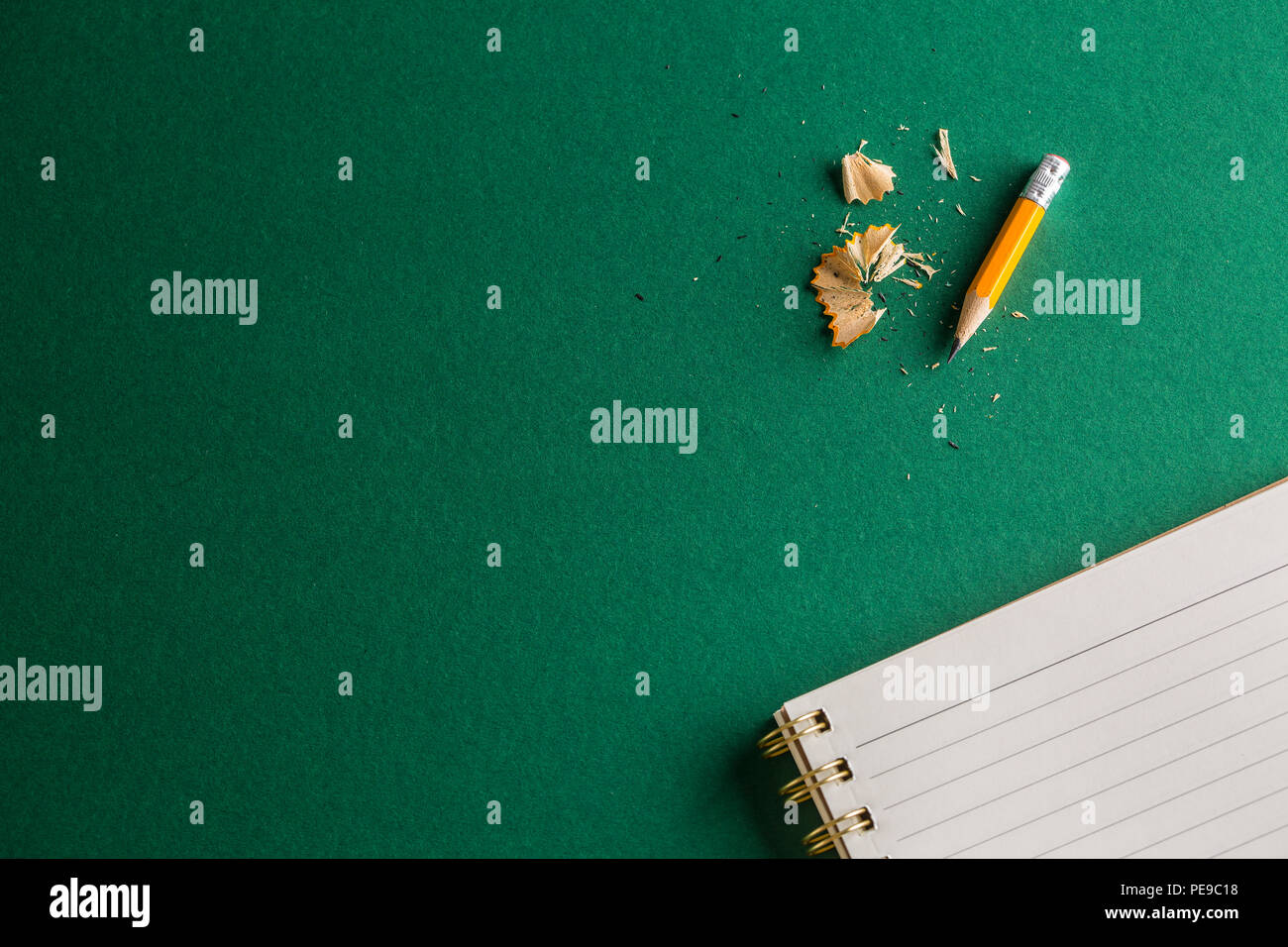 School notebook with pencil on a green background. Stock Photo