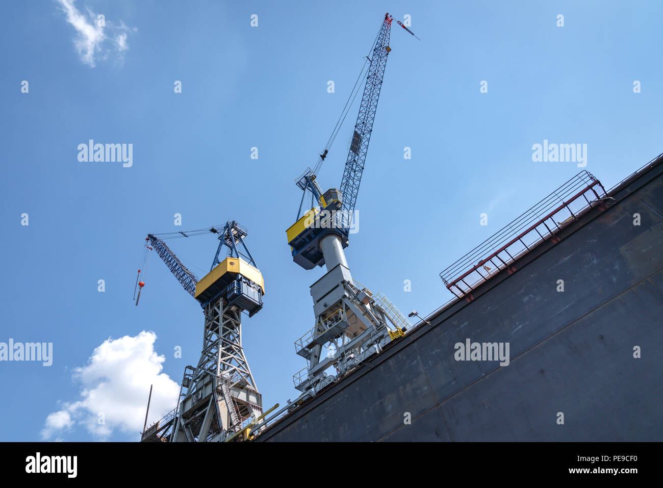 Two blue cranes view from below on a sunny day in the port of Hamburg, Germany Stock Photo