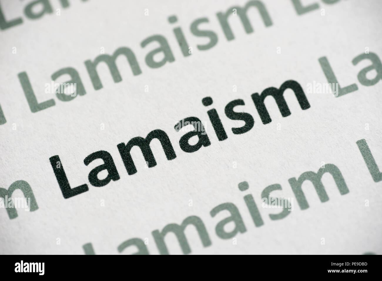 word Lamaism printed on white paper macro Stock Photo
