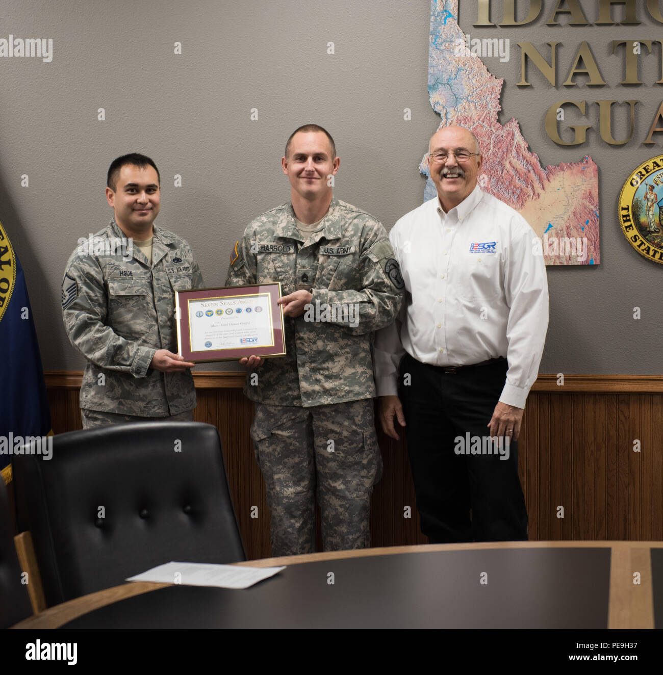 Bruce Wright, state chair of the Idaho Employer Support of the Guard and Reserve (ESGR), presents an award to Master Sgt. Carlos Hsue and Sgt. 1st Class Bou Harrold for their support as Joint Honor Guard at Gowen Field, Boise, Idaho, Nov. 19, 2015. (U.S. Air National Guard photo by Tech. Sgt. John Winn/Released) Stock Photo