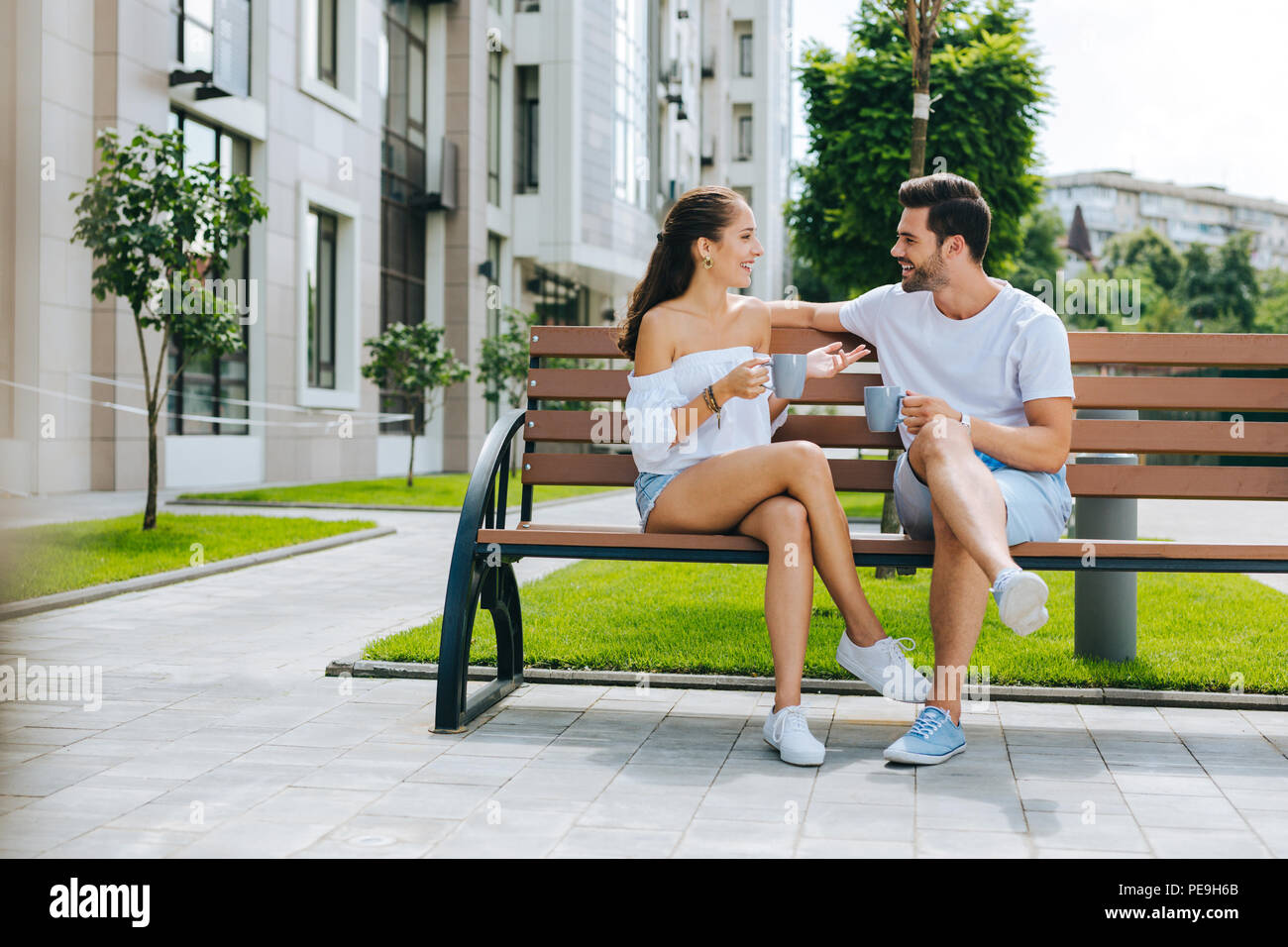 Happy nice people sitting together on the bench Stock Photo