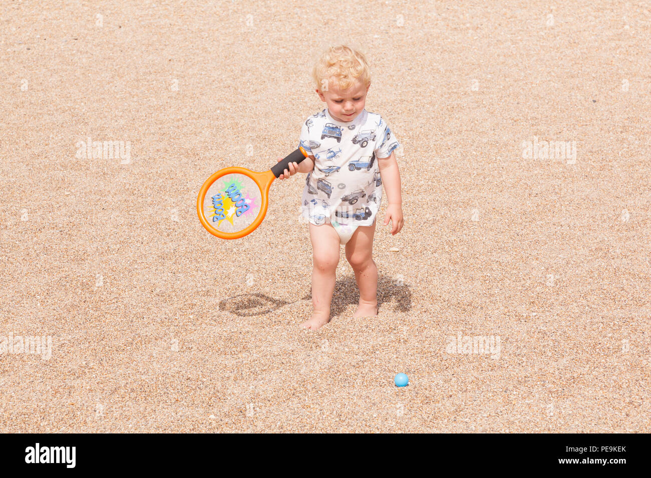 Two year old boy playing with a bat and ball, Devon, England, United Kingdom. Stock Photo