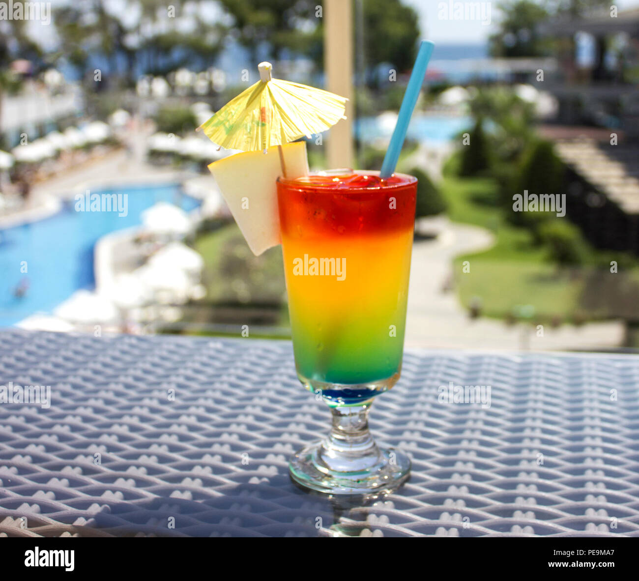 Bright cocktail with umbrella on background of the pool Stock Photo - Alamy