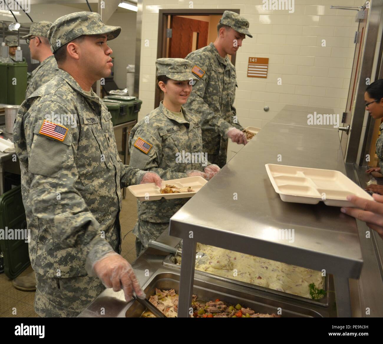 Spc. Marcos Houston and Pfc. Genephere Mata, 650th Regional Support Group, serve lunch to hungry Soldiers during their participation in a Joint Culinary Training Program exercise at the George W. Dunaway Army Reserve Center in Sloan, Nev., Nov. 15. Sponsored by the Joint Culinary Training Program, this training is designed to be a module for identifying those personnel who will compete at the annual U.S. Army Culinary Arts Competition held at Fort Lee, Va. Stock Photo