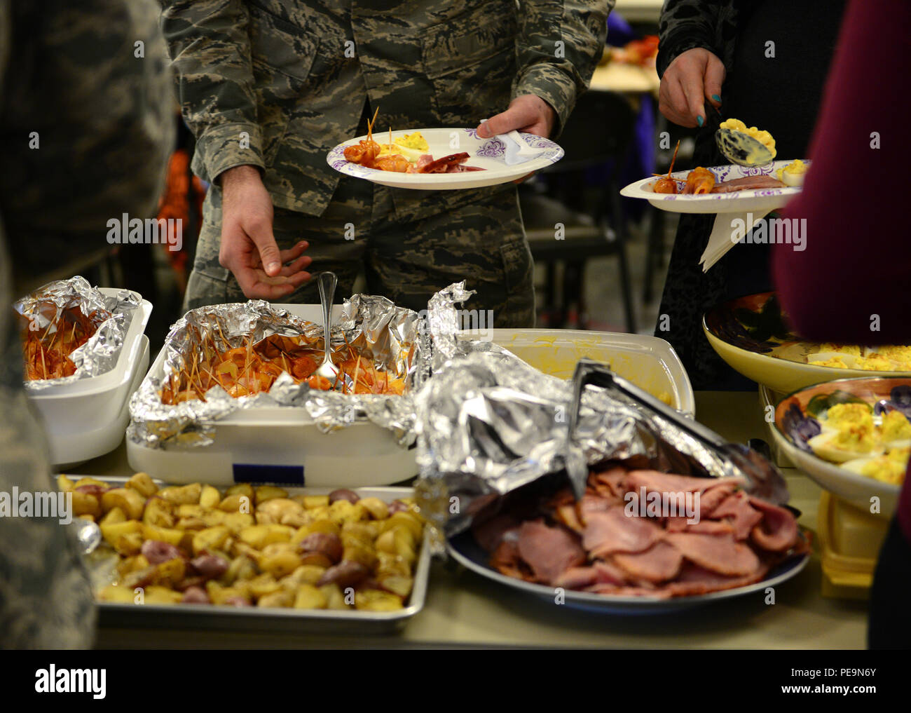 U.S. Air Force Airmen with the 354th Communications Squadron enjoy food at a Thanksgiving