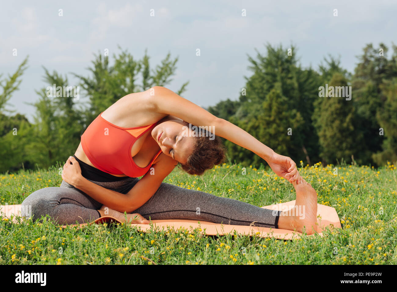 Dark-haired woman wearing leggings practicing yoga asana Stock Photo
