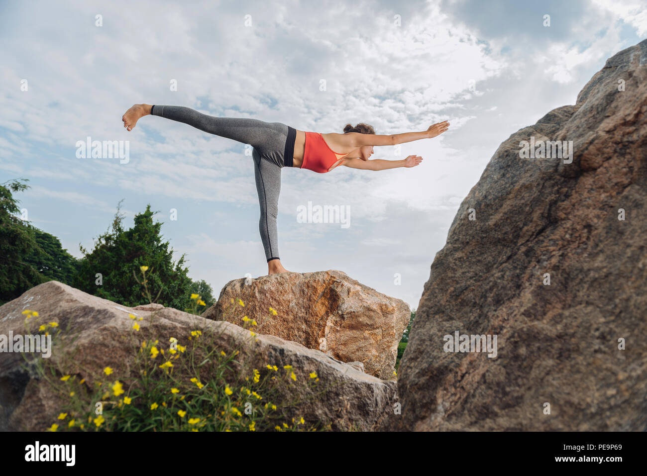 Sportswoman wearing grey leggings standing in yoga pose Stock Photo