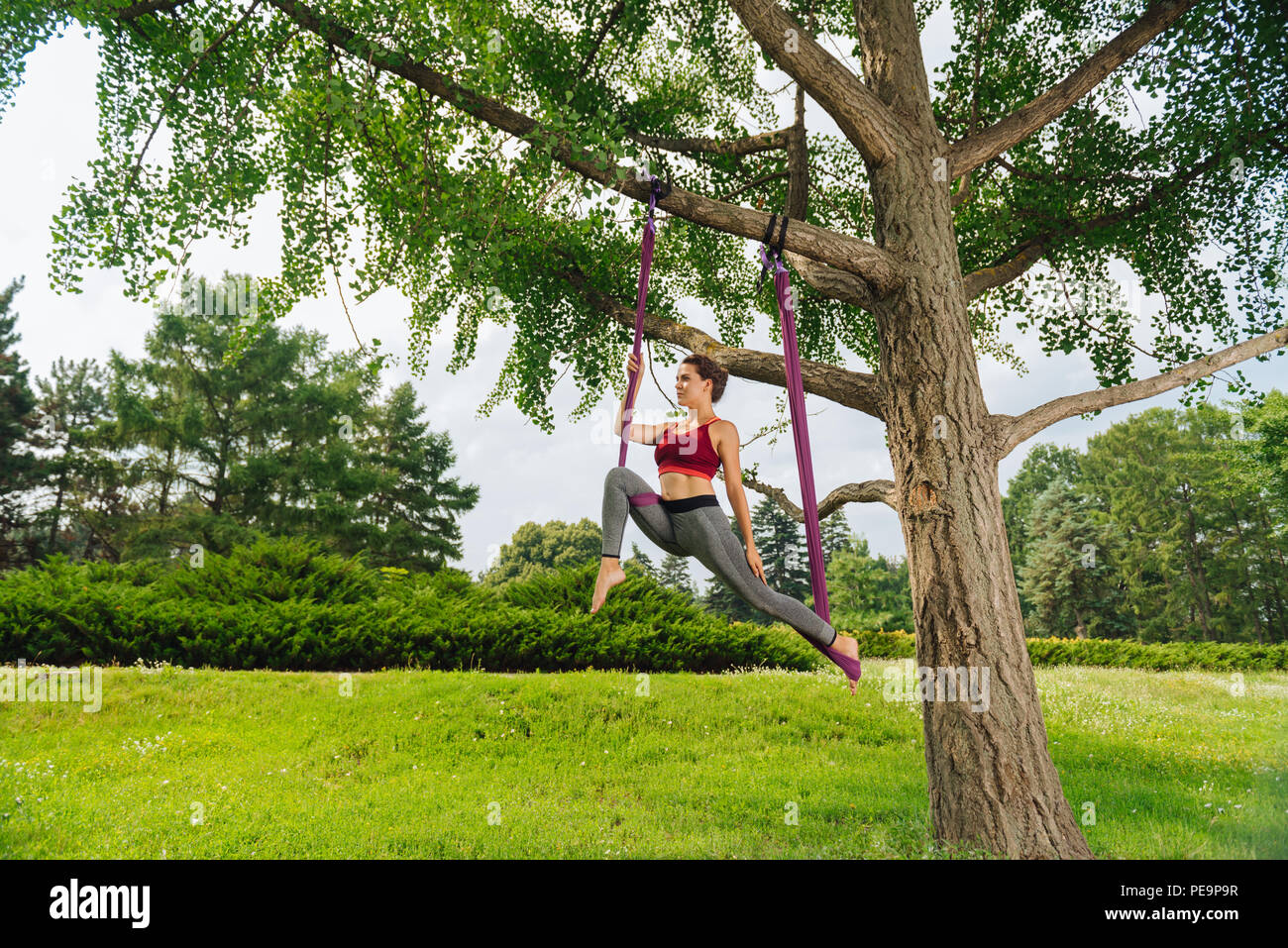 Woman practicing fly yoga showing very challenging pose Stock Photo