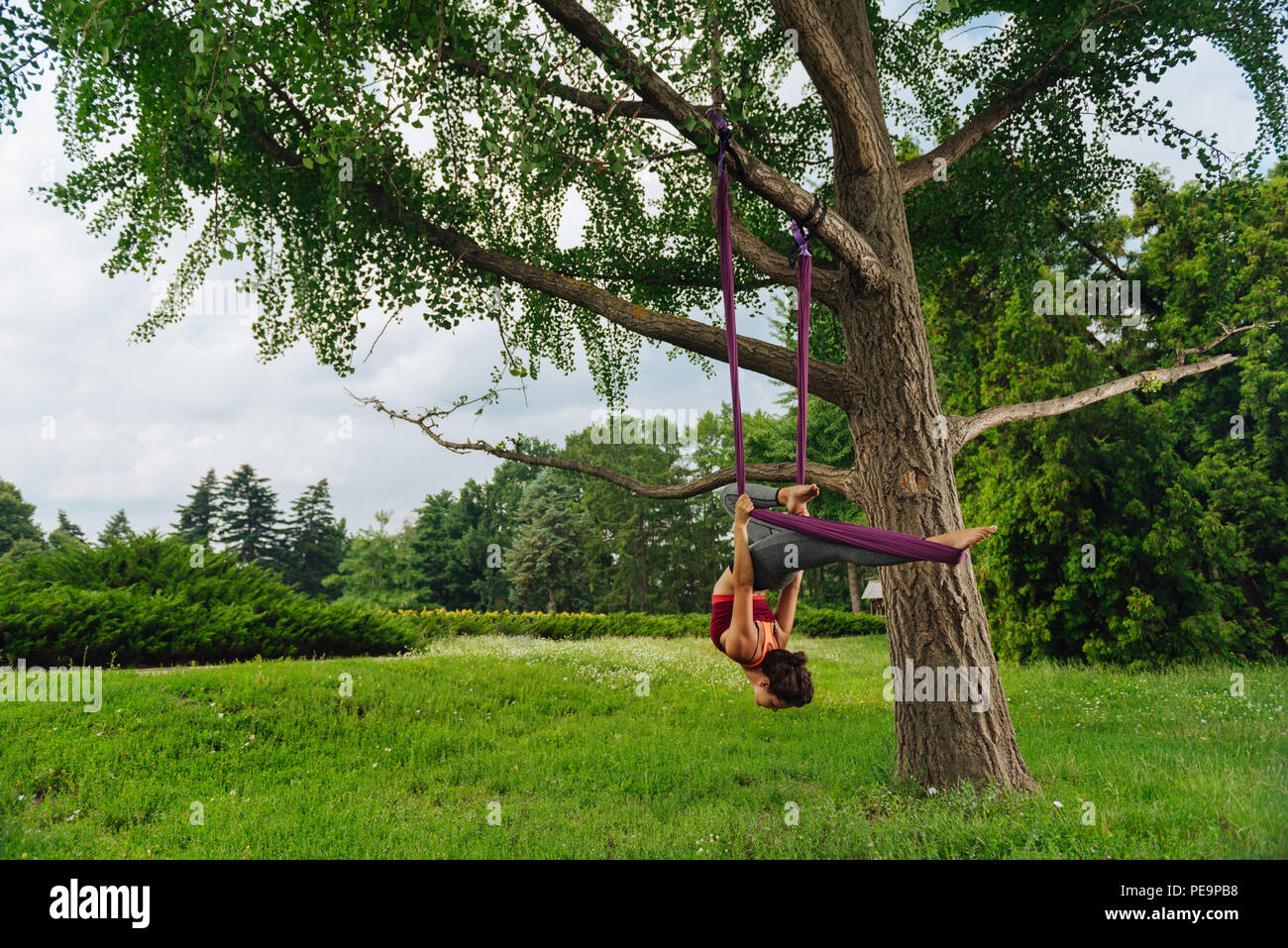 Dark-haired yoga teacher showing challenging fly yoga pose Stock Photo