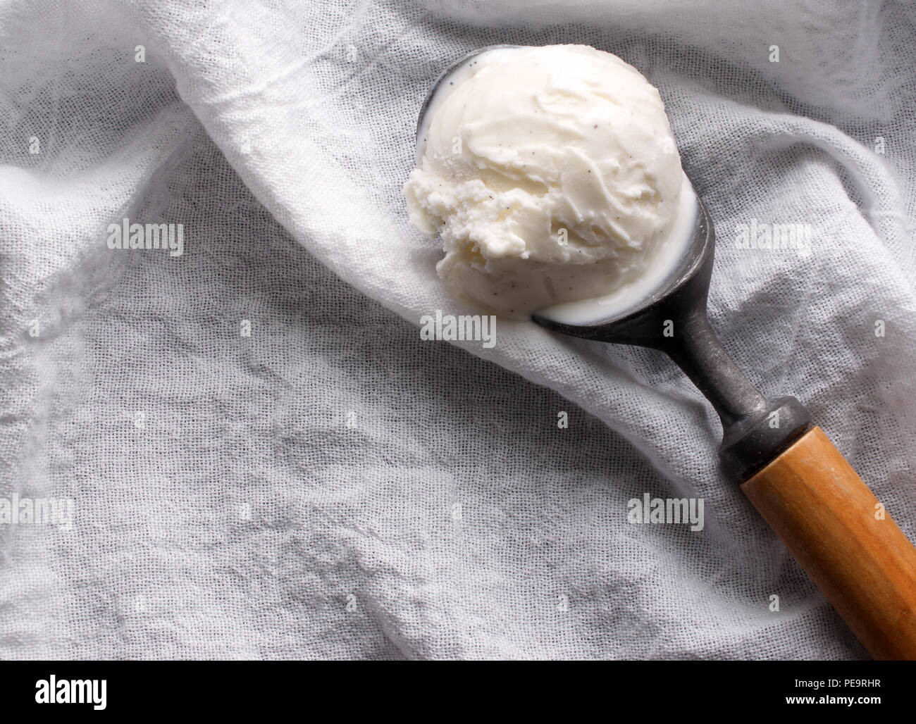 https://c8.alamy.com/comp/PE9RHR/close-up-photograph-of-melting-vanilla-ice-cream-in-a-vintage-ice-cream-scoop-with-a-wooden-handle-the-scoop-is-sitting-on-a-white-woven-cotton-cloth-PE9RHR.jpg