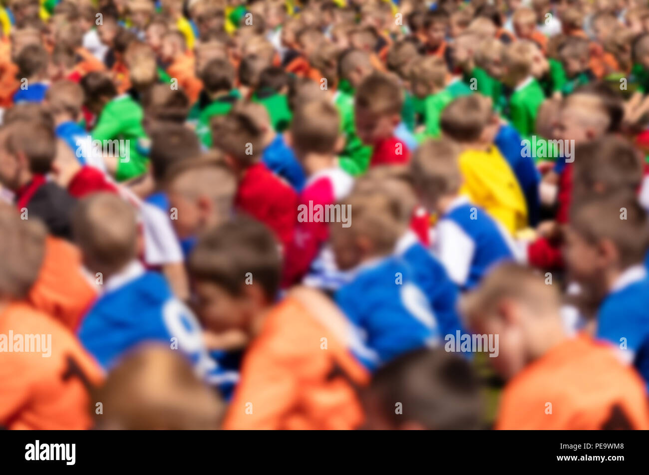 Kids Sport Football Players Sitting on a Sports Field. Youth Football Background. Soccer Tournament for Kids Stock Photo
