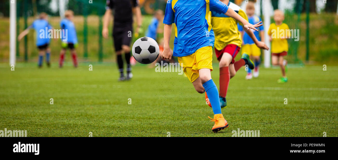 Junior Football Match Competition. Two Young Footballers Running and