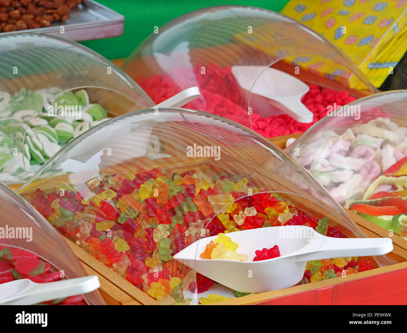 Close up of colorful gummy sweets bears in market with white plastic scoops Stock Photo