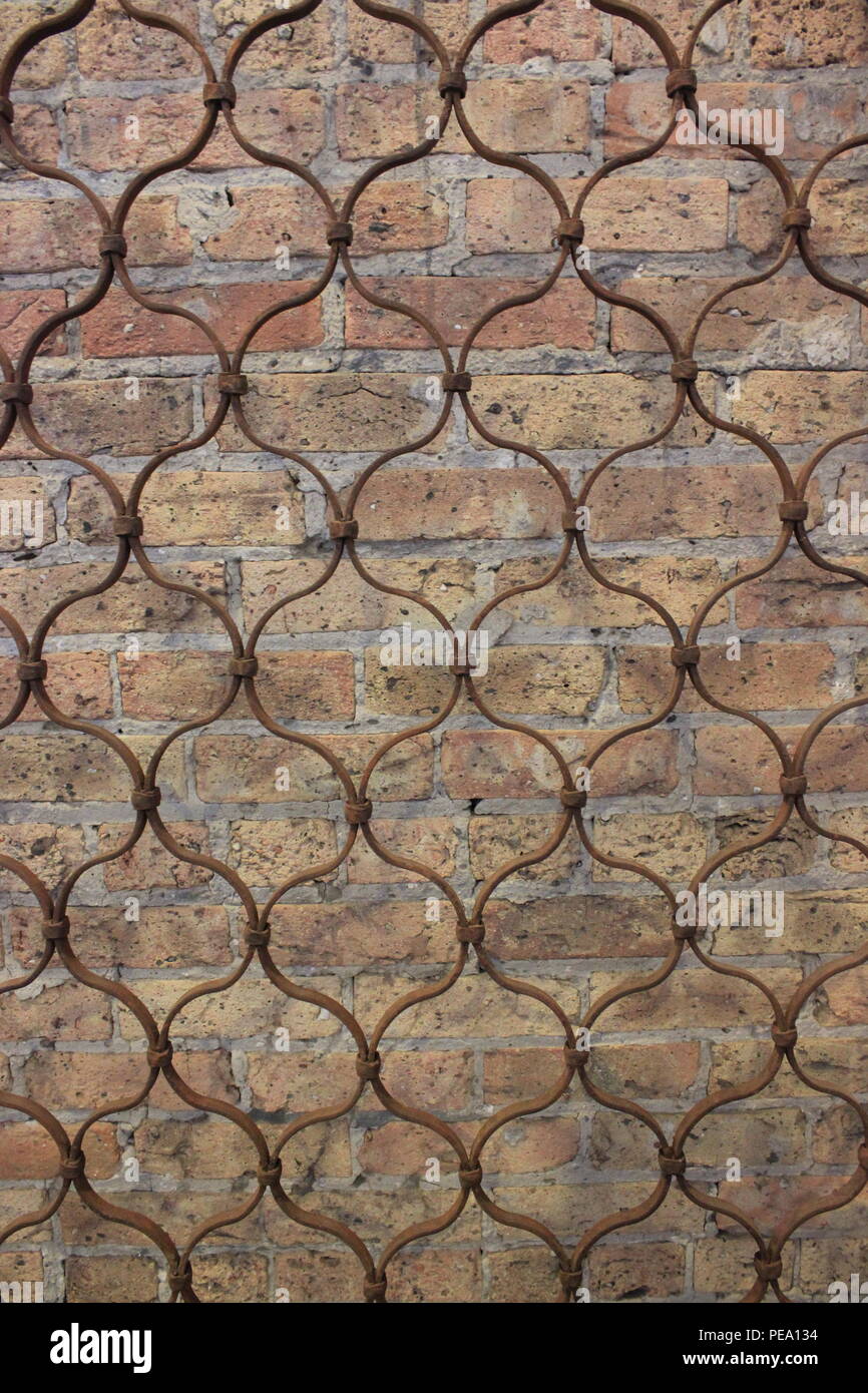 Decorative and intricate metal wire grille with a double ogee arch pattern at Architectural