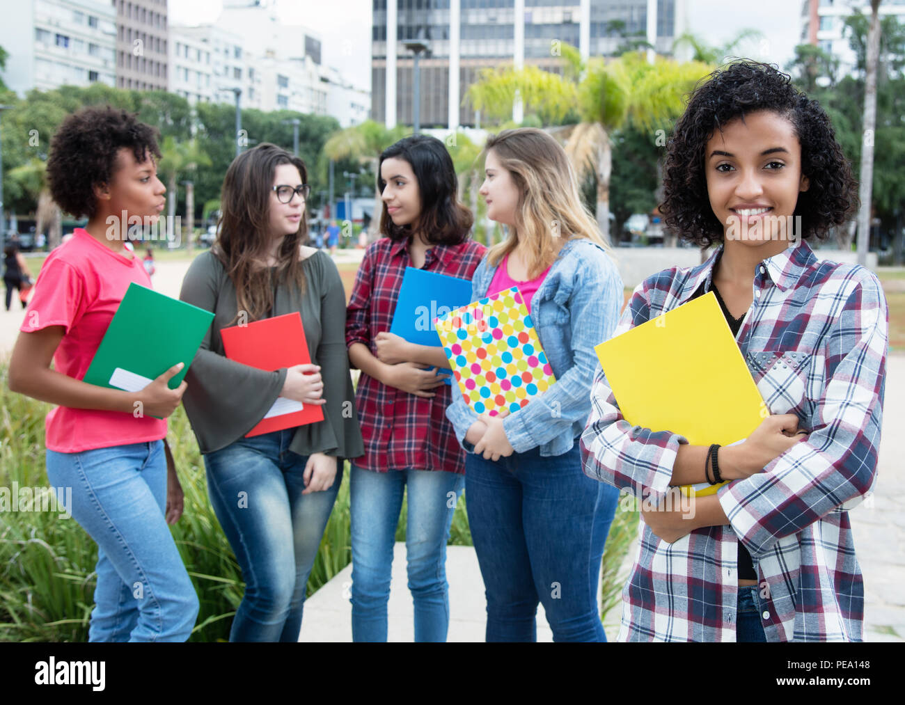 Latin american female student with group of international students outdoors on campus of university Stock Photo